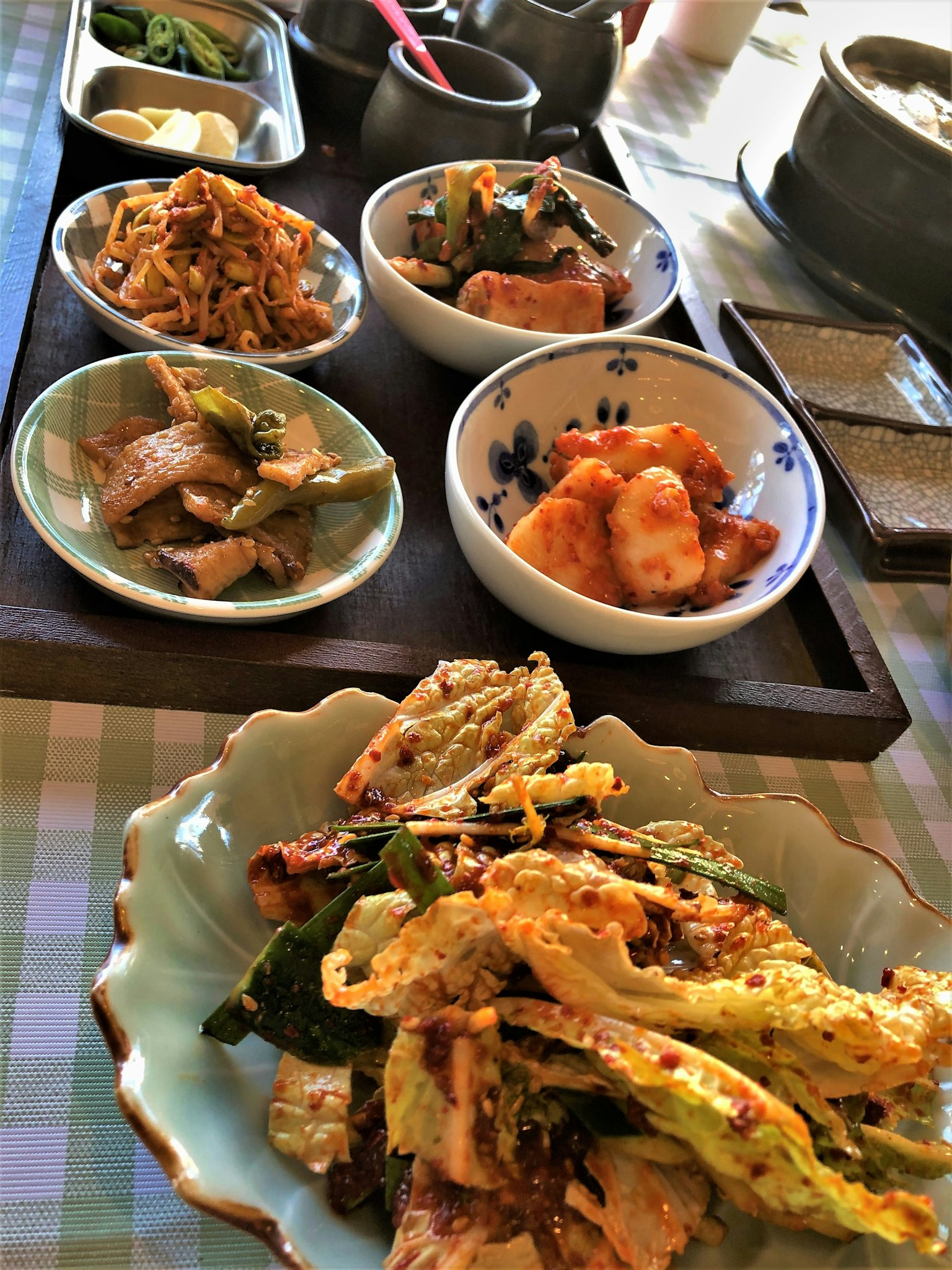 一组韩国菜肴，包含多个小碗和一个主菜盘