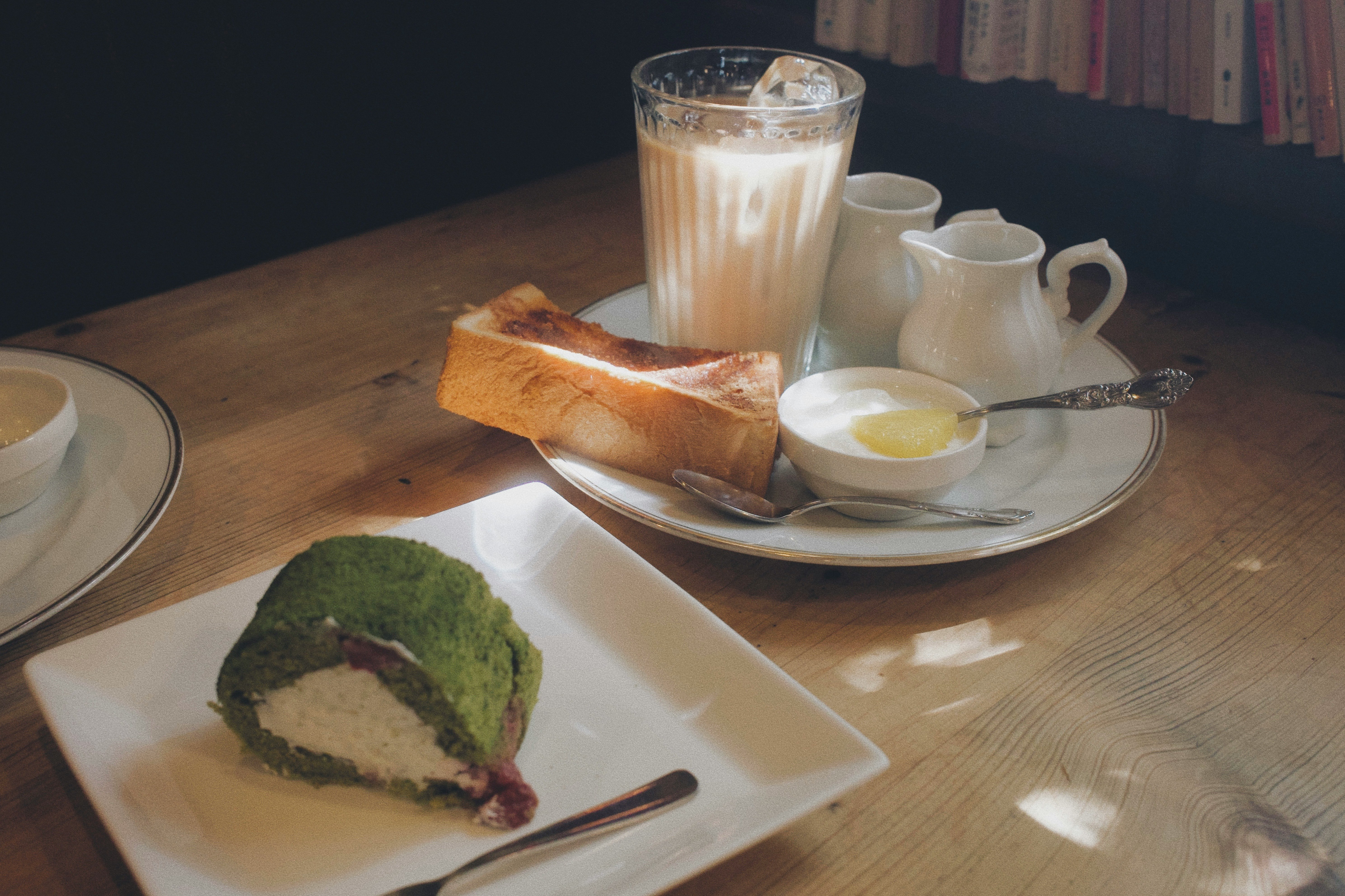 Matcha-Rollkuchen und Milchtee auf einem Holztisch