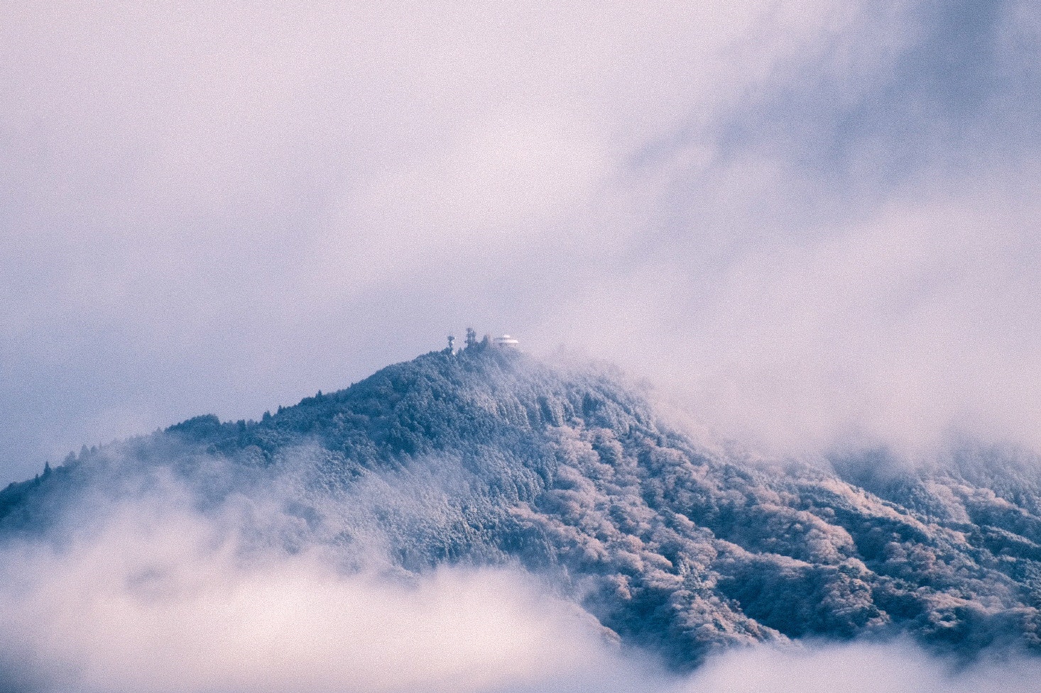霧に包まれた山頂と雲の流れる山の風景