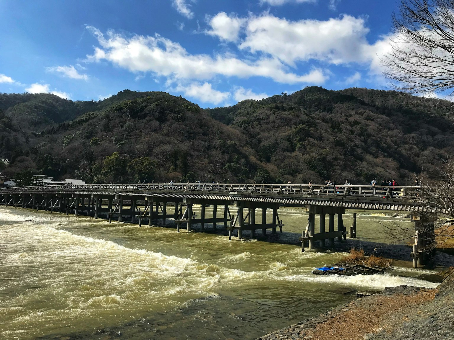 ทิวทัศน์ที่สวยงามของแม่น้ำพร้อมสะพานและภูเขาในพื้นหลัง