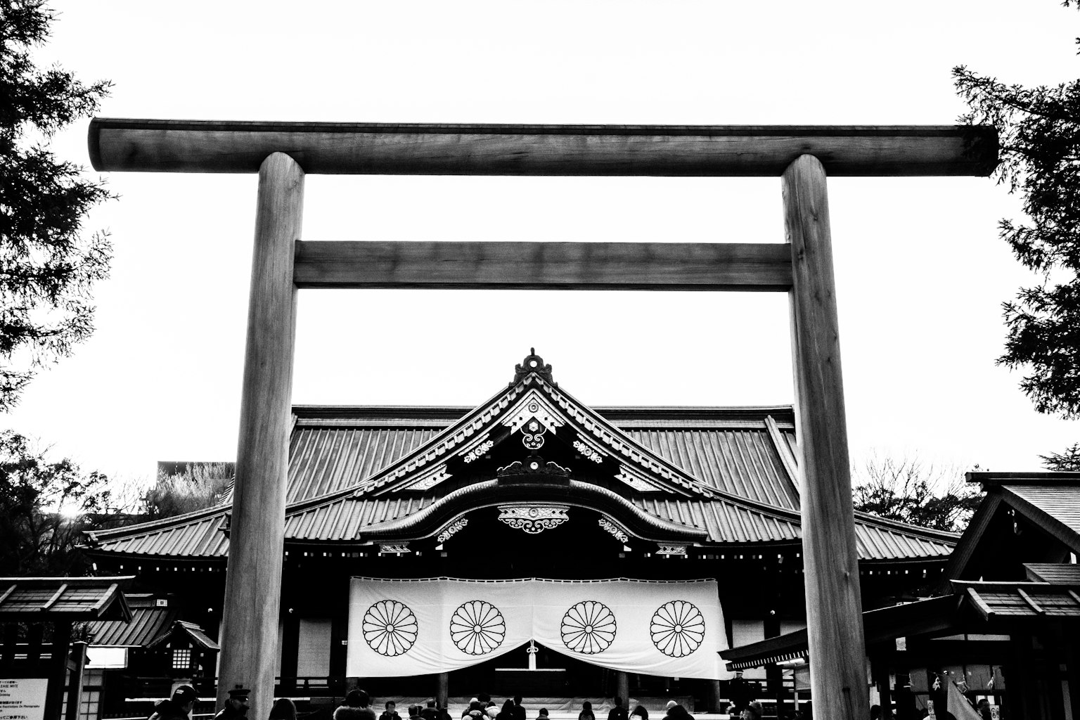 Black and white view of a torii gate and shrine building