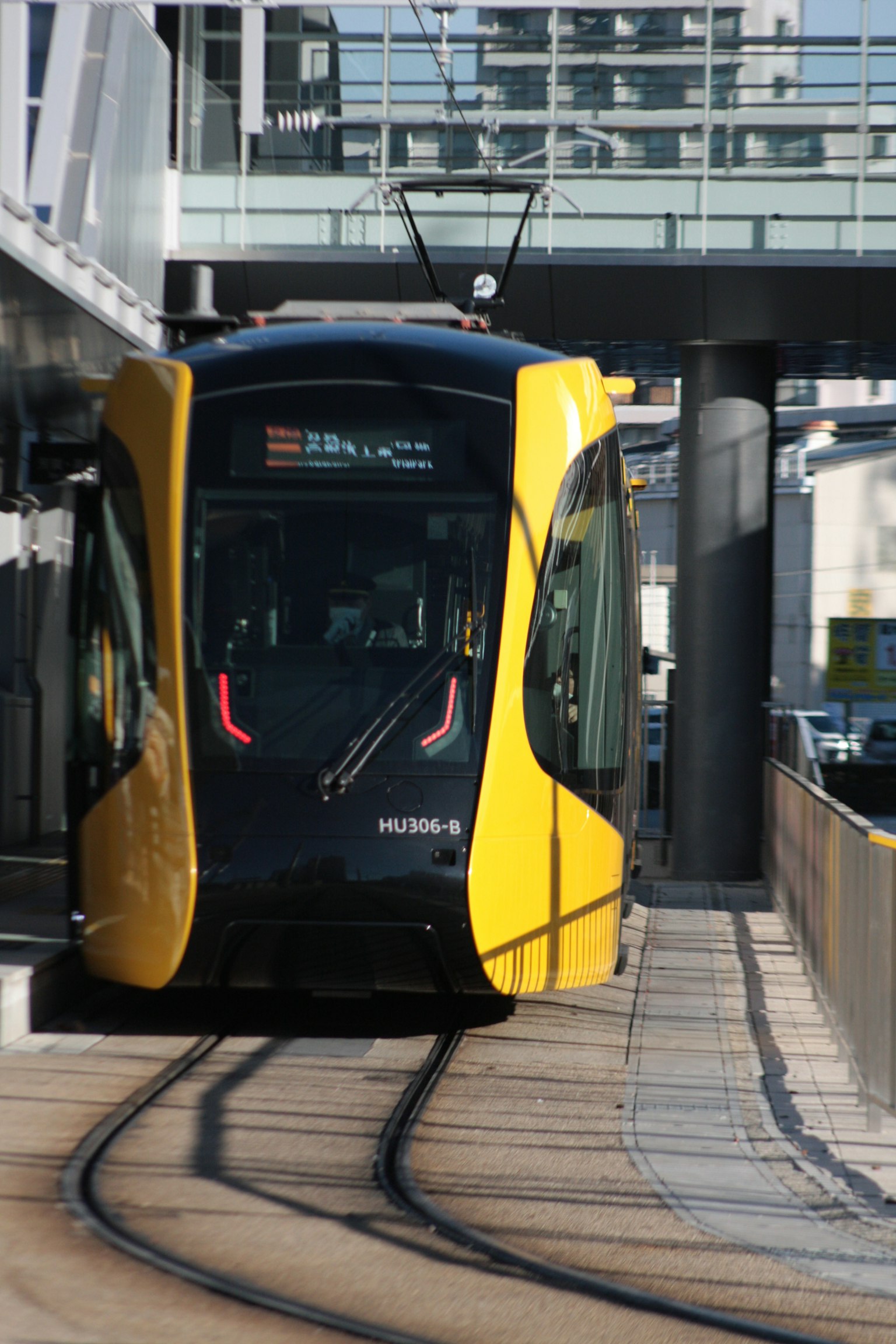 Un tram jaune et noir arrivant à une station