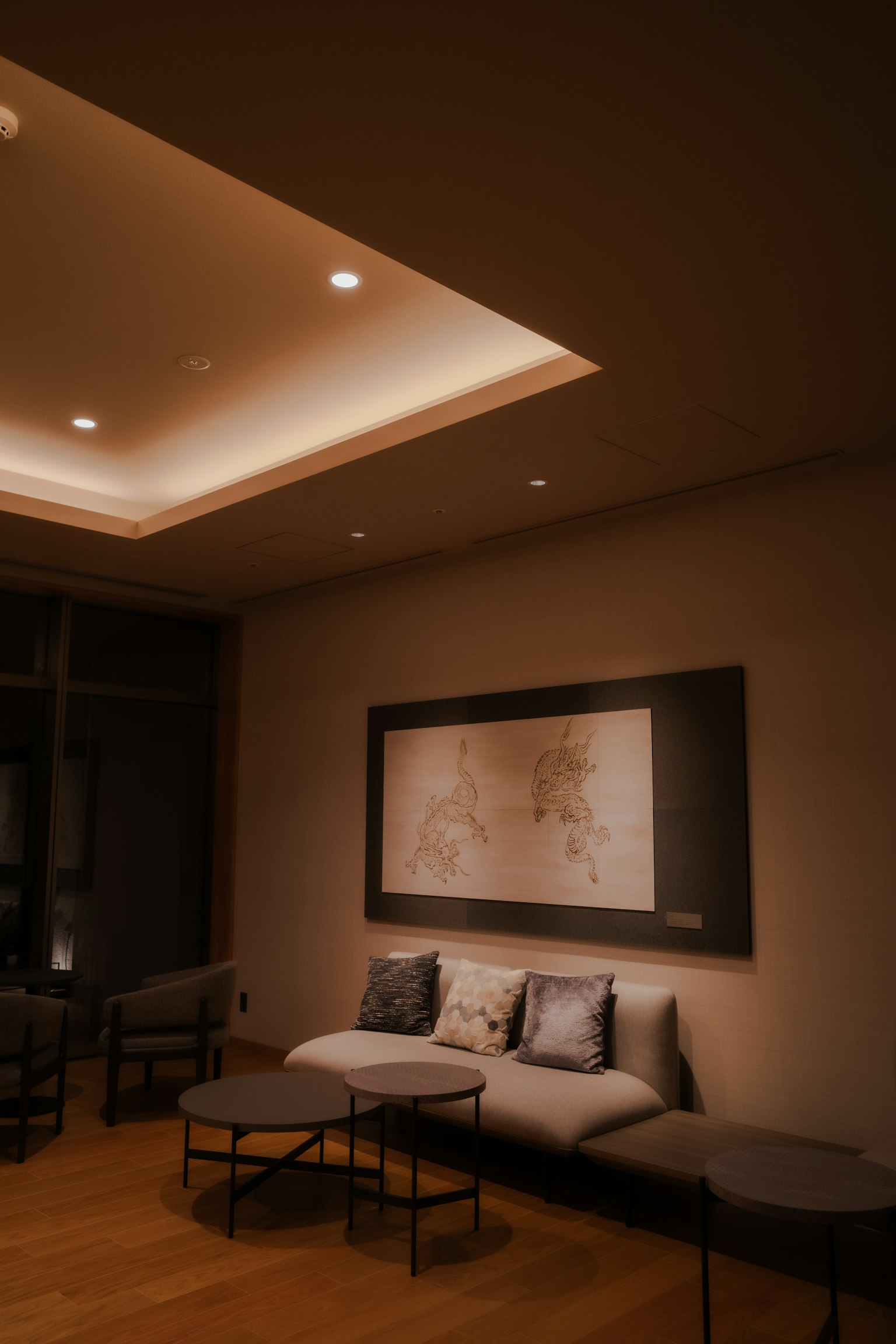 A cozy room with a sofa and tables featuring a map artwork on the wall