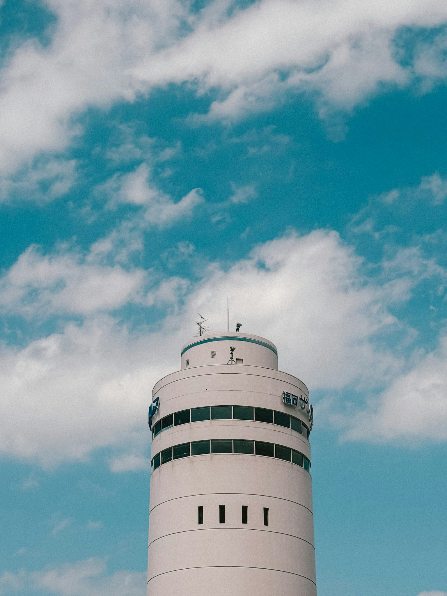 青空の下にそびえる丸い展望塔の建物