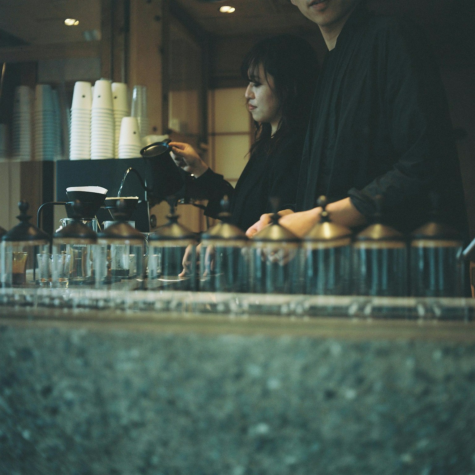 Barista và nhân viên chuẩn bị cà phê tại quầy cà phê