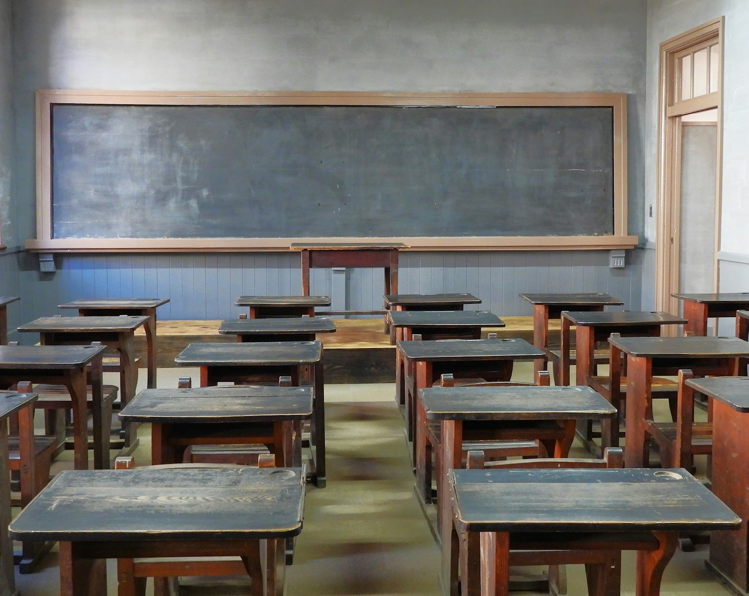 古い教室の内部 木製の机と黒板がある