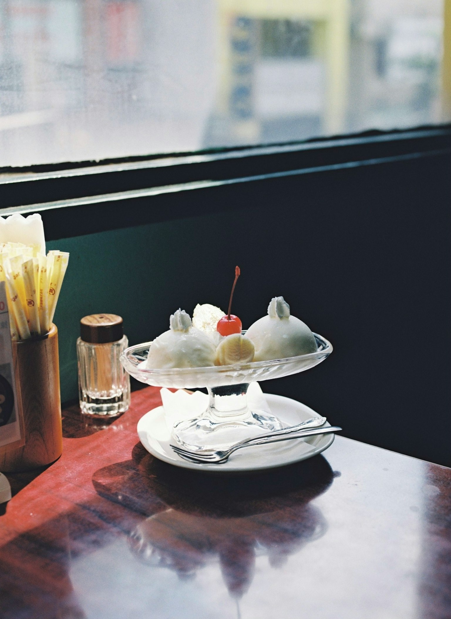 Đĩa tráng miệng với kem và quả cherry trên bàn