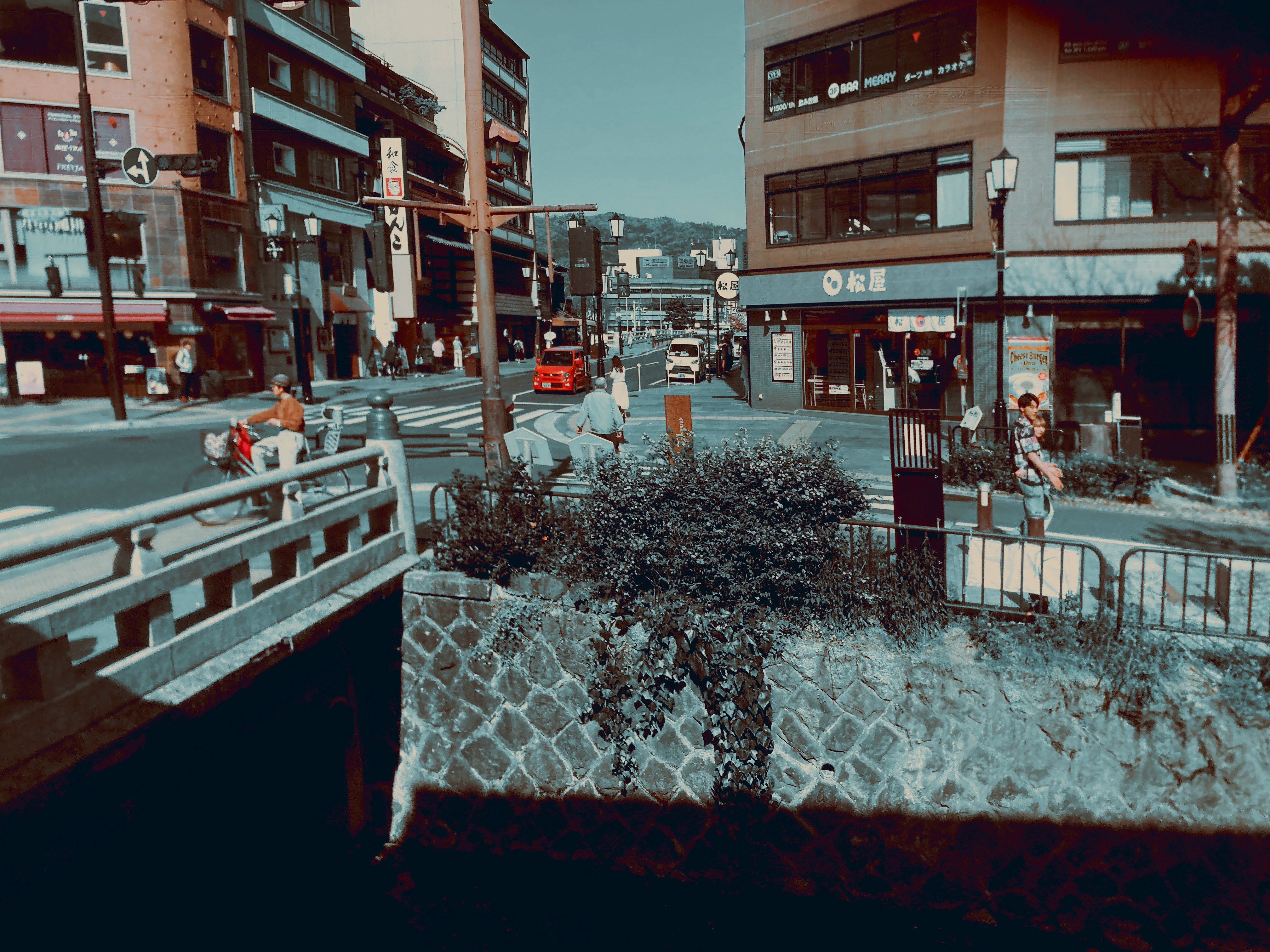 Uferpromenade und Stadtstraßen mit Blick auf eine Brücke mit Geländer