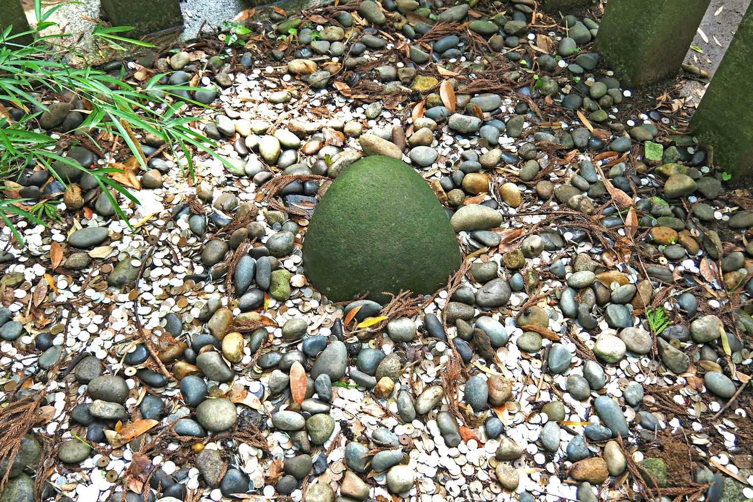 Piedra verde rodeada de piedras en un jardín