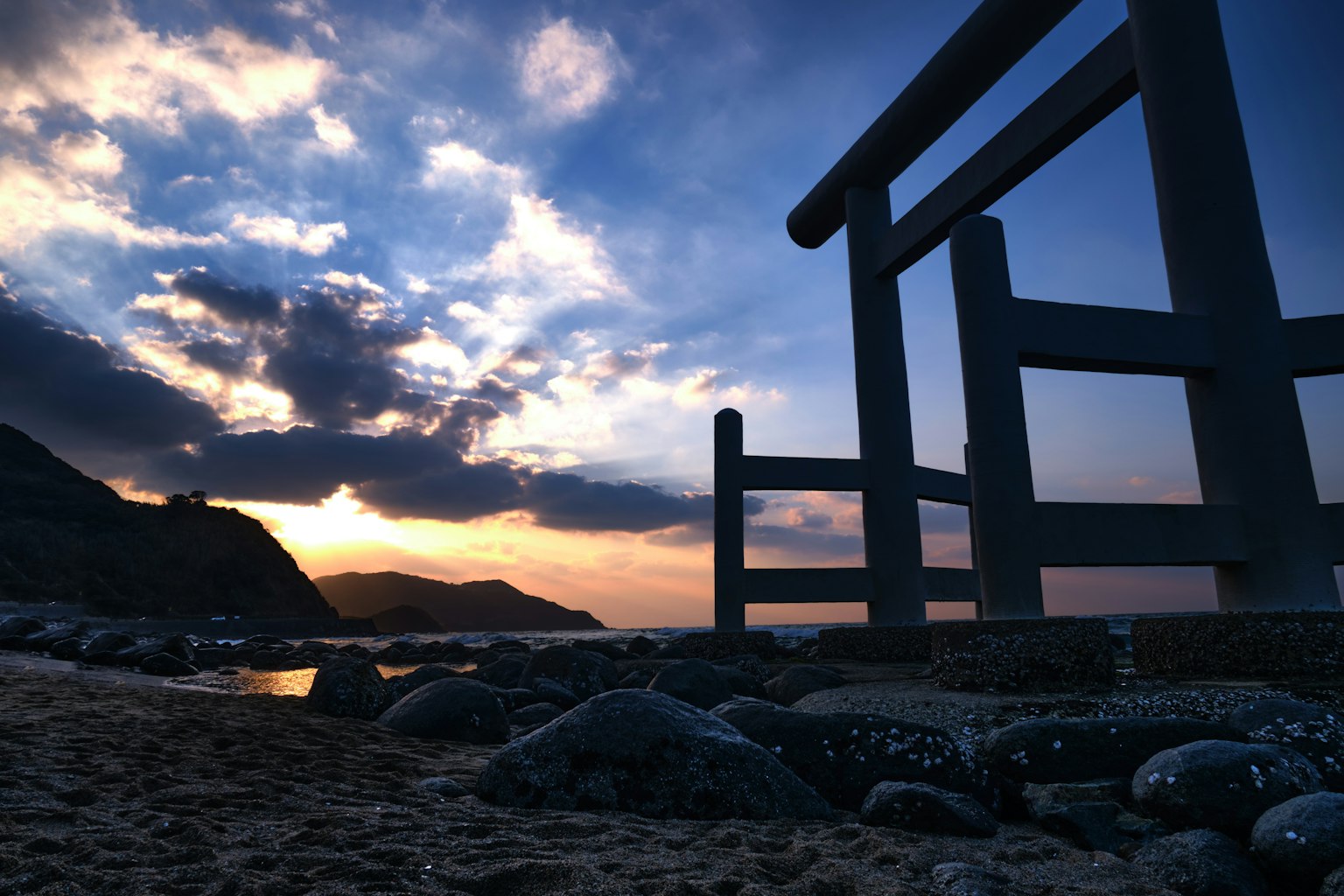 Torii sulla spiaggia con un bellissimo tramonto