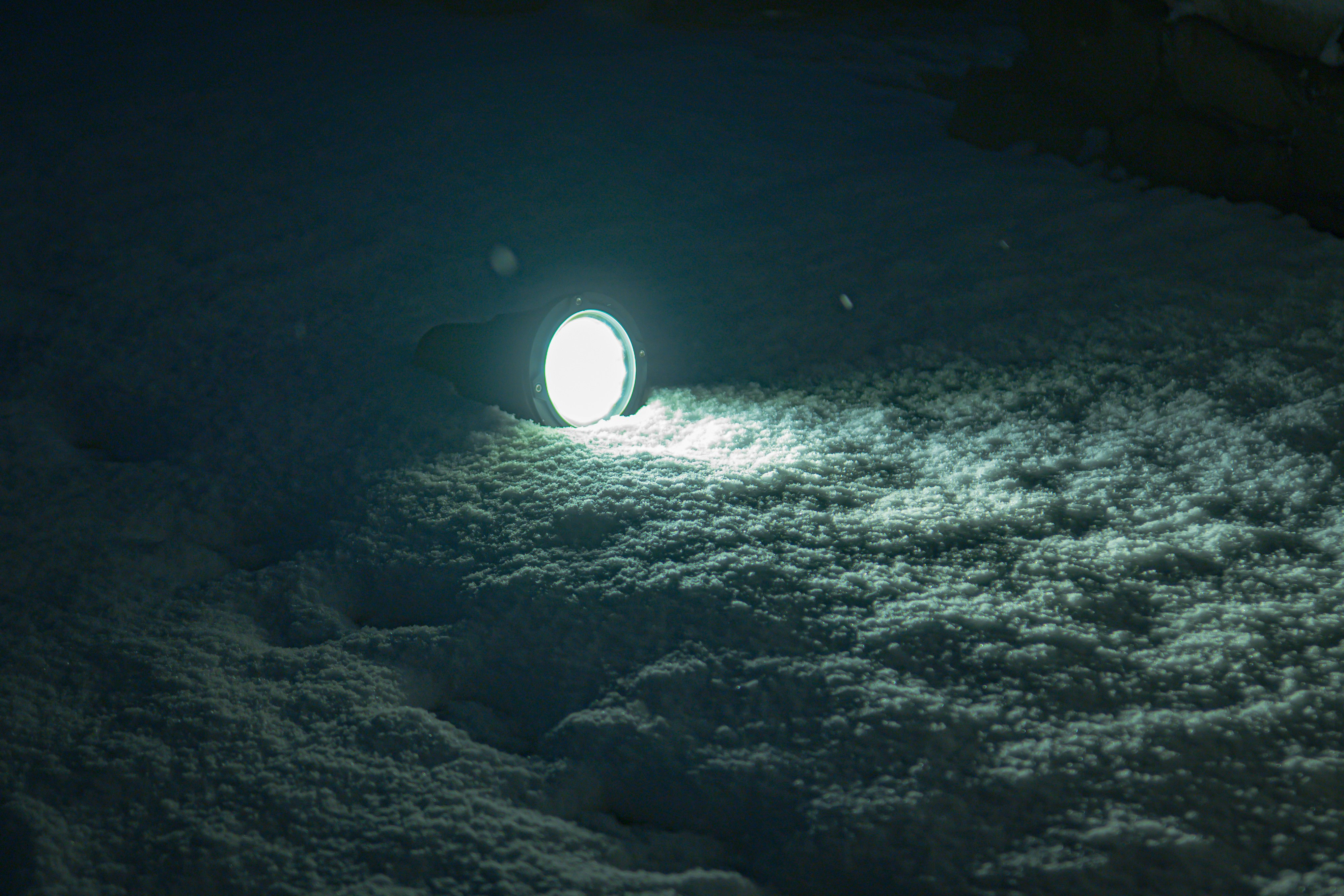雪の上に置かれた光るオブジェクトの夜の写真