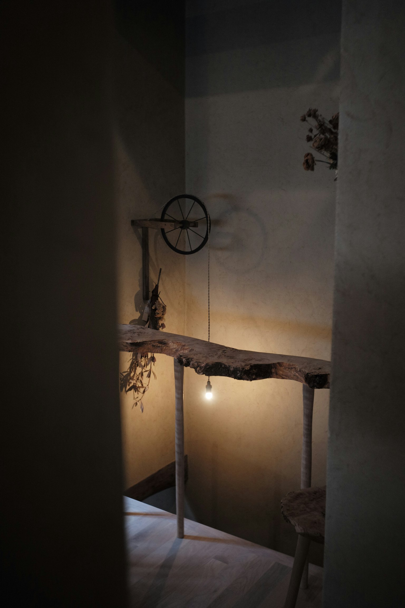 Spazio scarsamente illuminato con mensola di legno e lampadina appesa