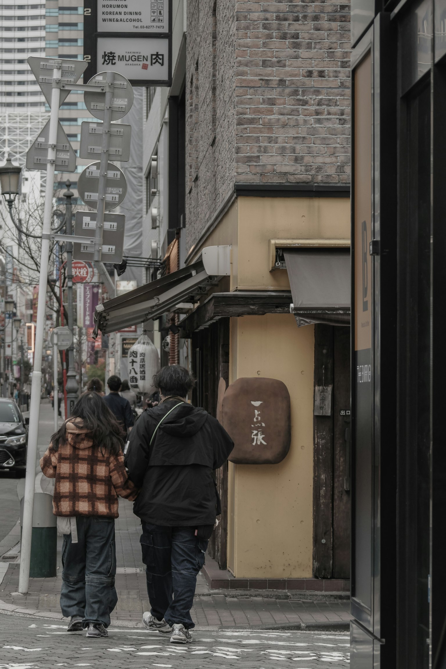 两个人在黄色建筑旁边的街道上走