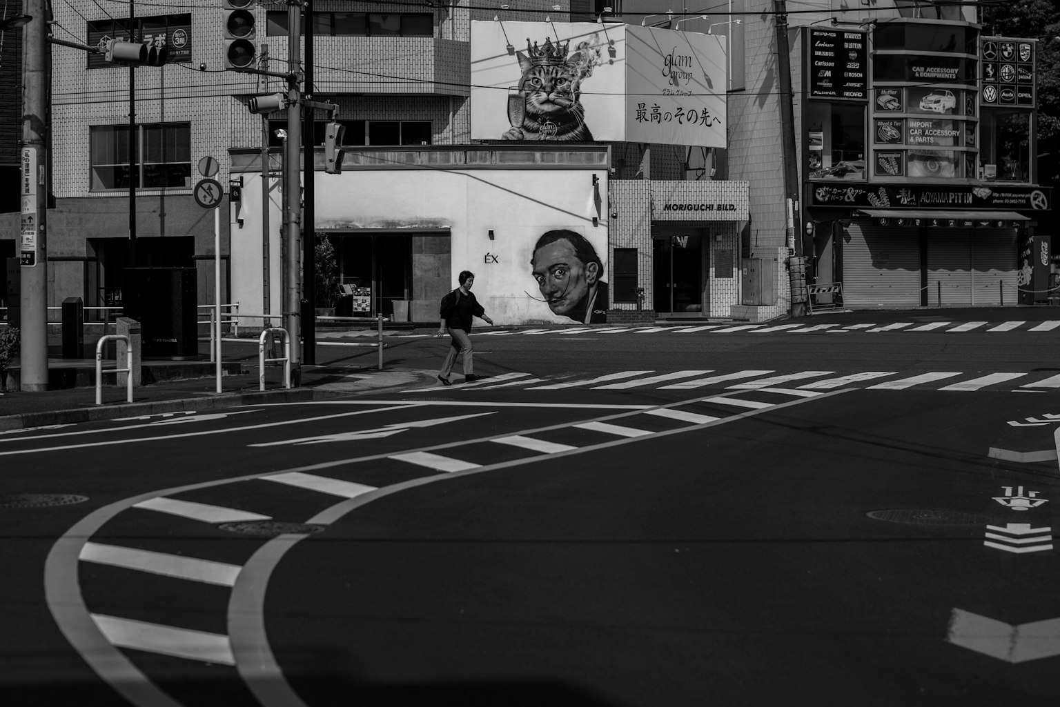 Scena urbana in bianco e nero con una persona all'angolo della strada e linee bianche distintive