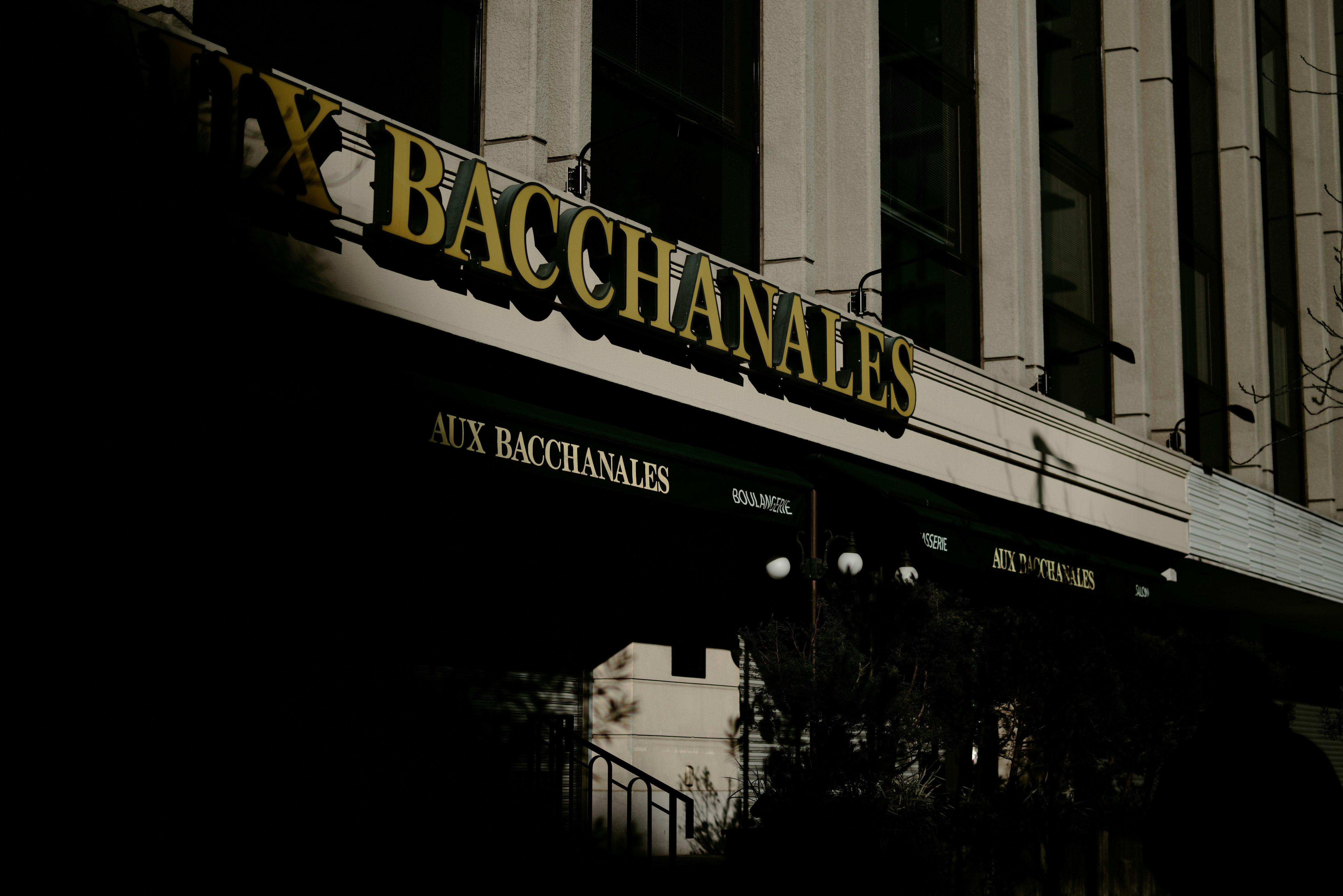 東京のレストラン「AUX BACCHANALES」の看板と日差しの影