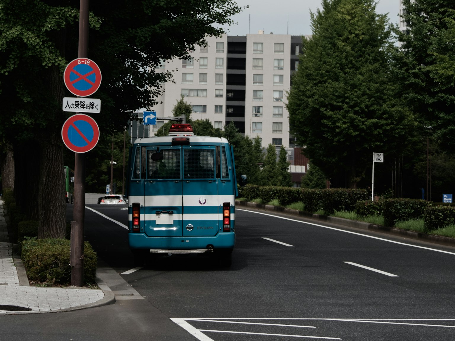 Un autobus blu che percorre la strada con alberi verdi lungo il percorso
