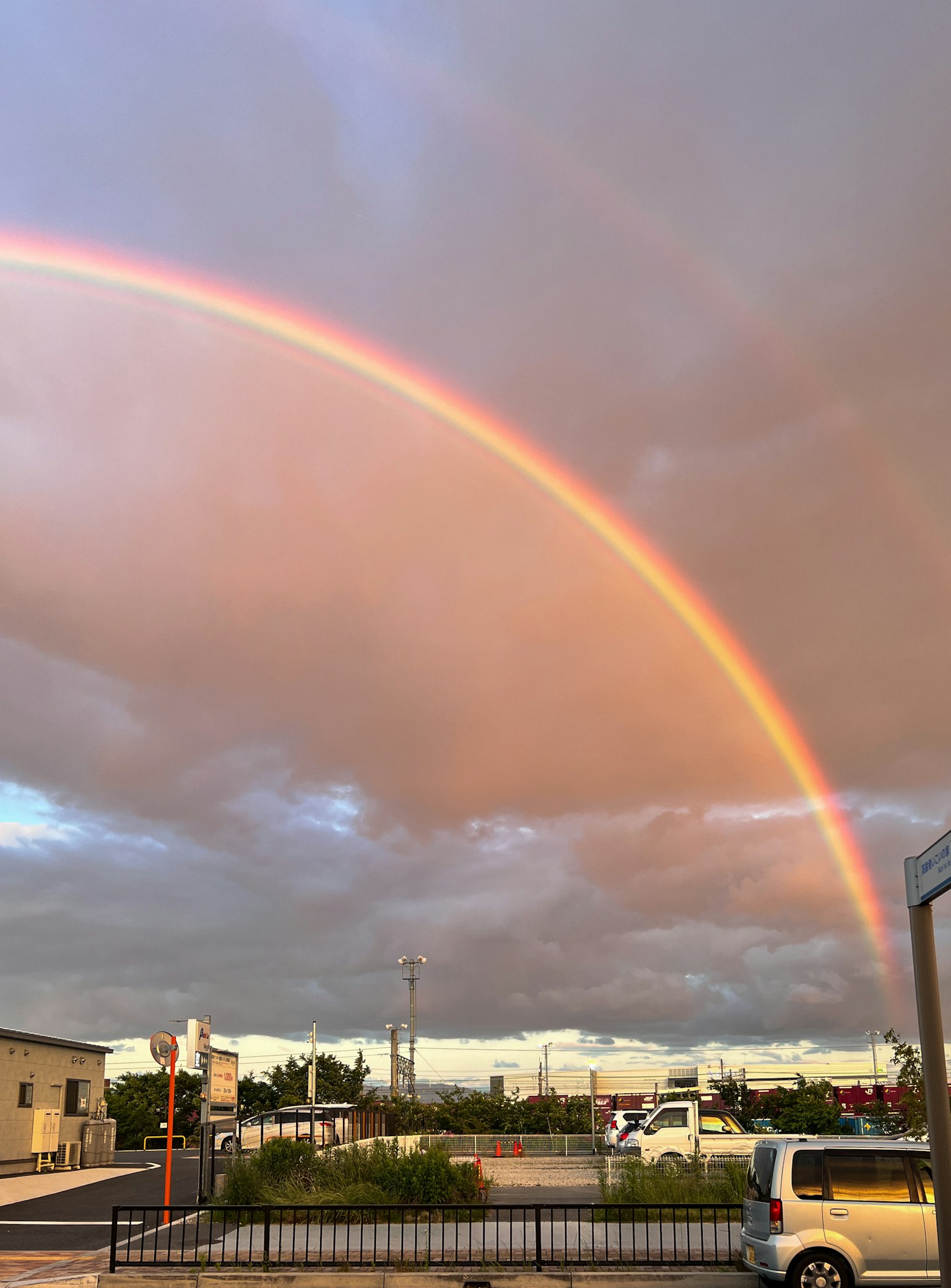 Ein lebhaftes Regenbogen, das sich über den Himmel mit Wolken im Hintergrund erstreckt