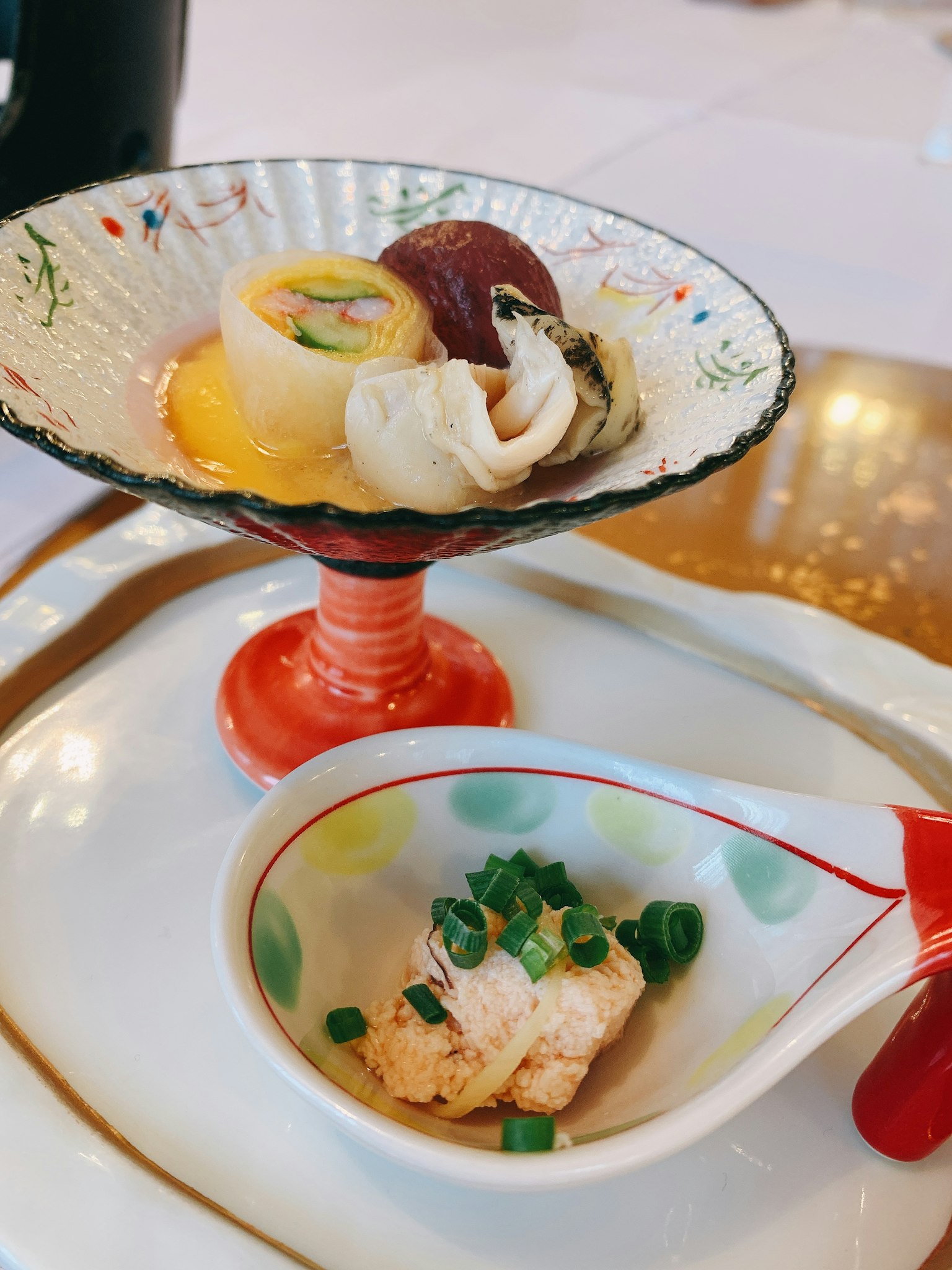Dolci giapponesi colorati serviti su un pied rosso con un piatto di cibo guarnito su un piatto bianco