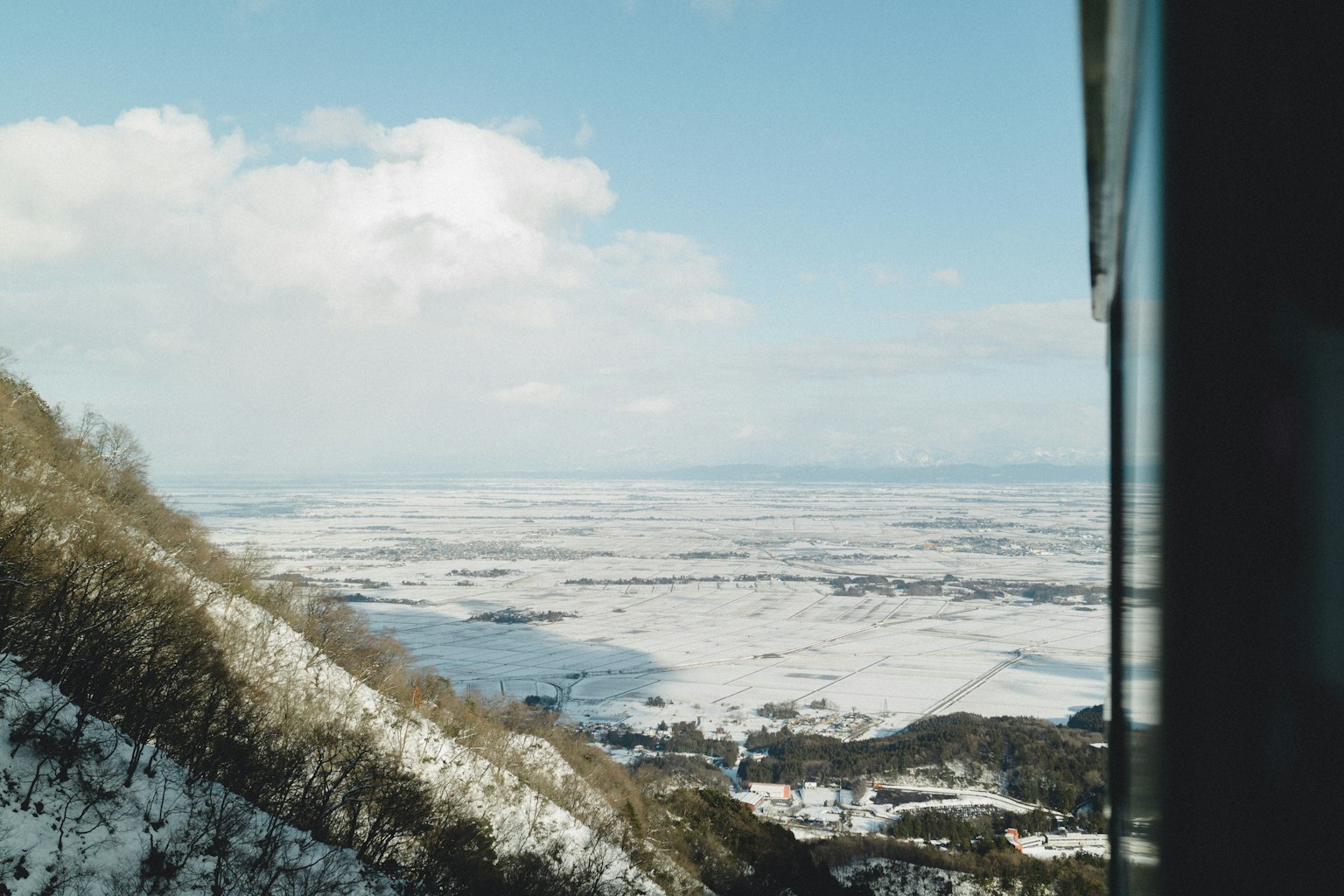 산비탈에서 바라본 눈 덮인 평원과 파란 하늘