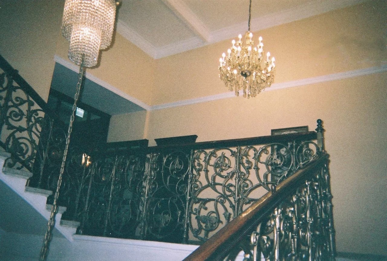 staircase hall with chandelier and ornate railing