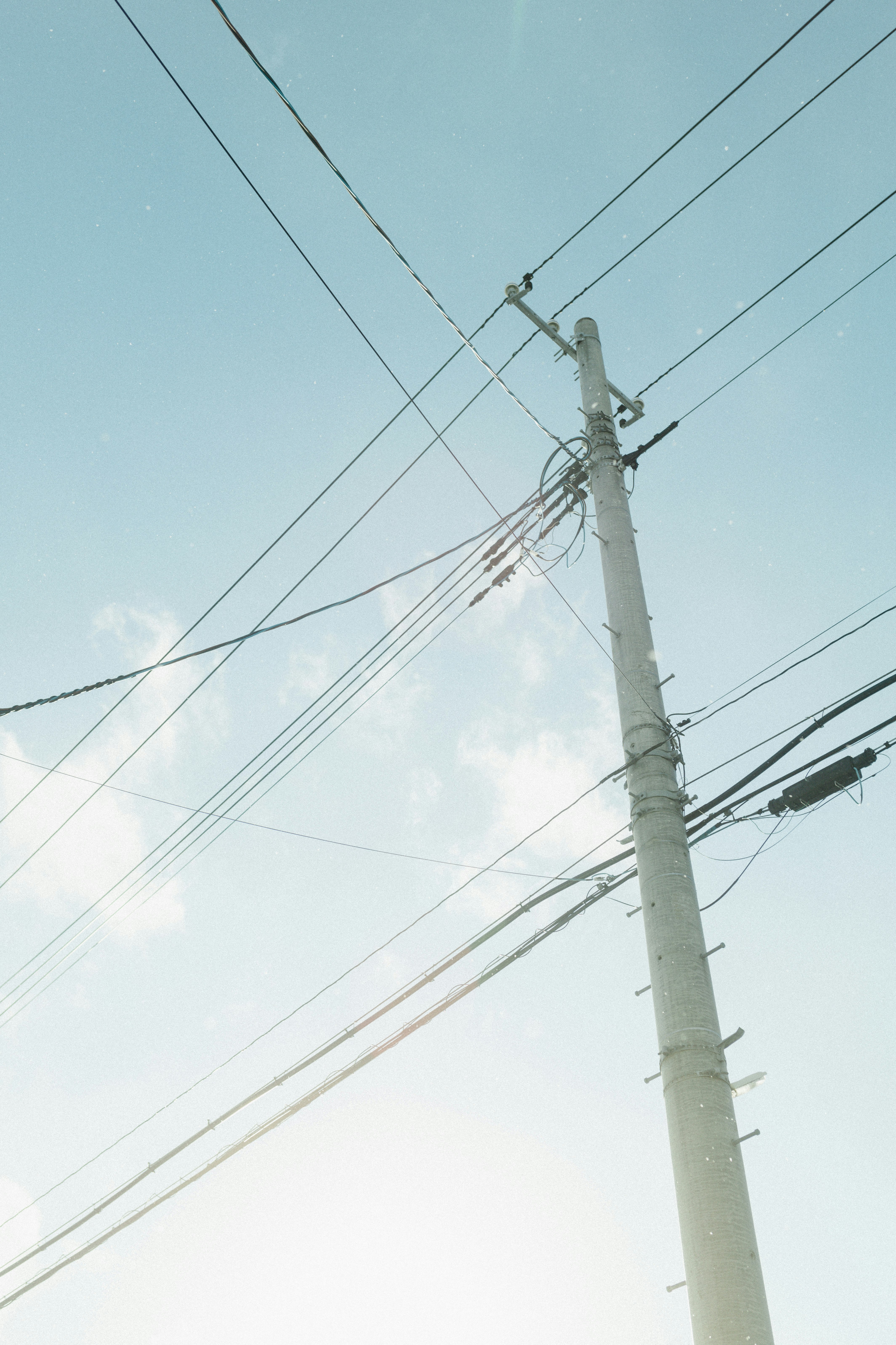 cables eléctricos y poste de servicios con cielo azul