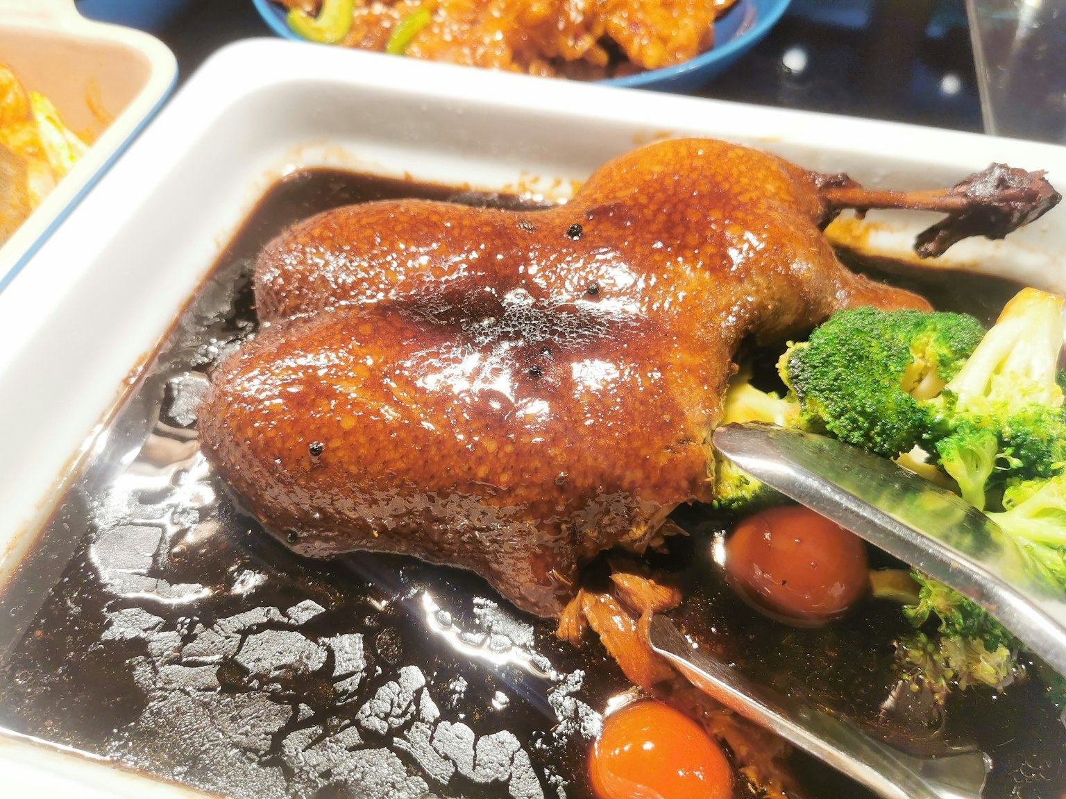 Hidangan bebek glasir dengan brokoli dan tomat ceri