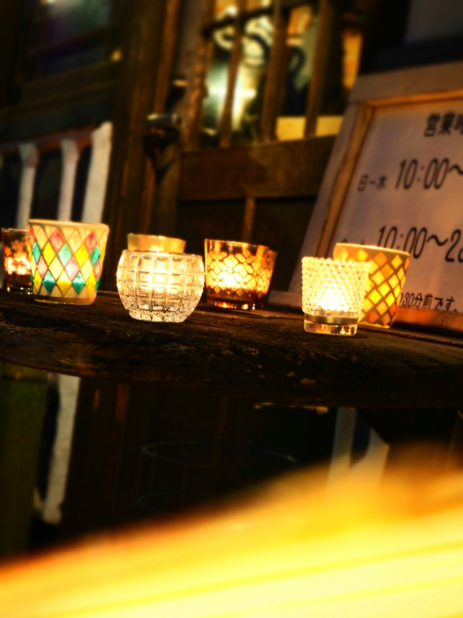 Bunte Kerzenhalter auf einem Holztisch, die warmes Licht ausstrahlen