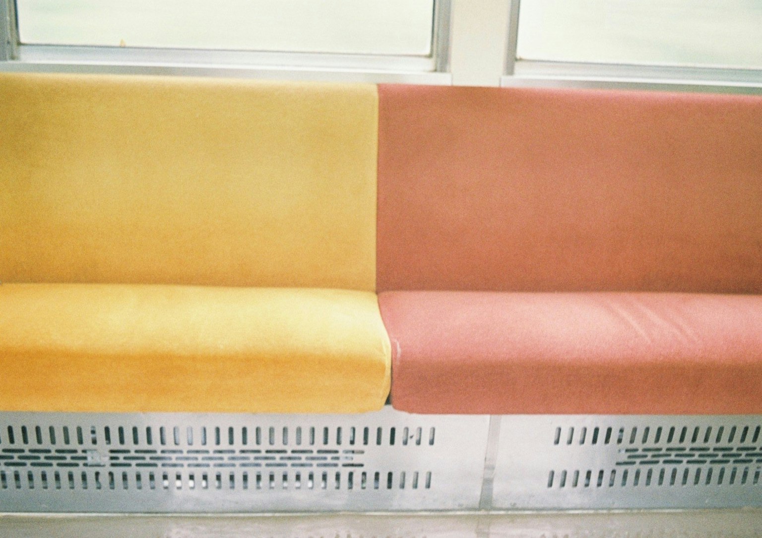 Bangku dengan bantal kuning dan merah muda