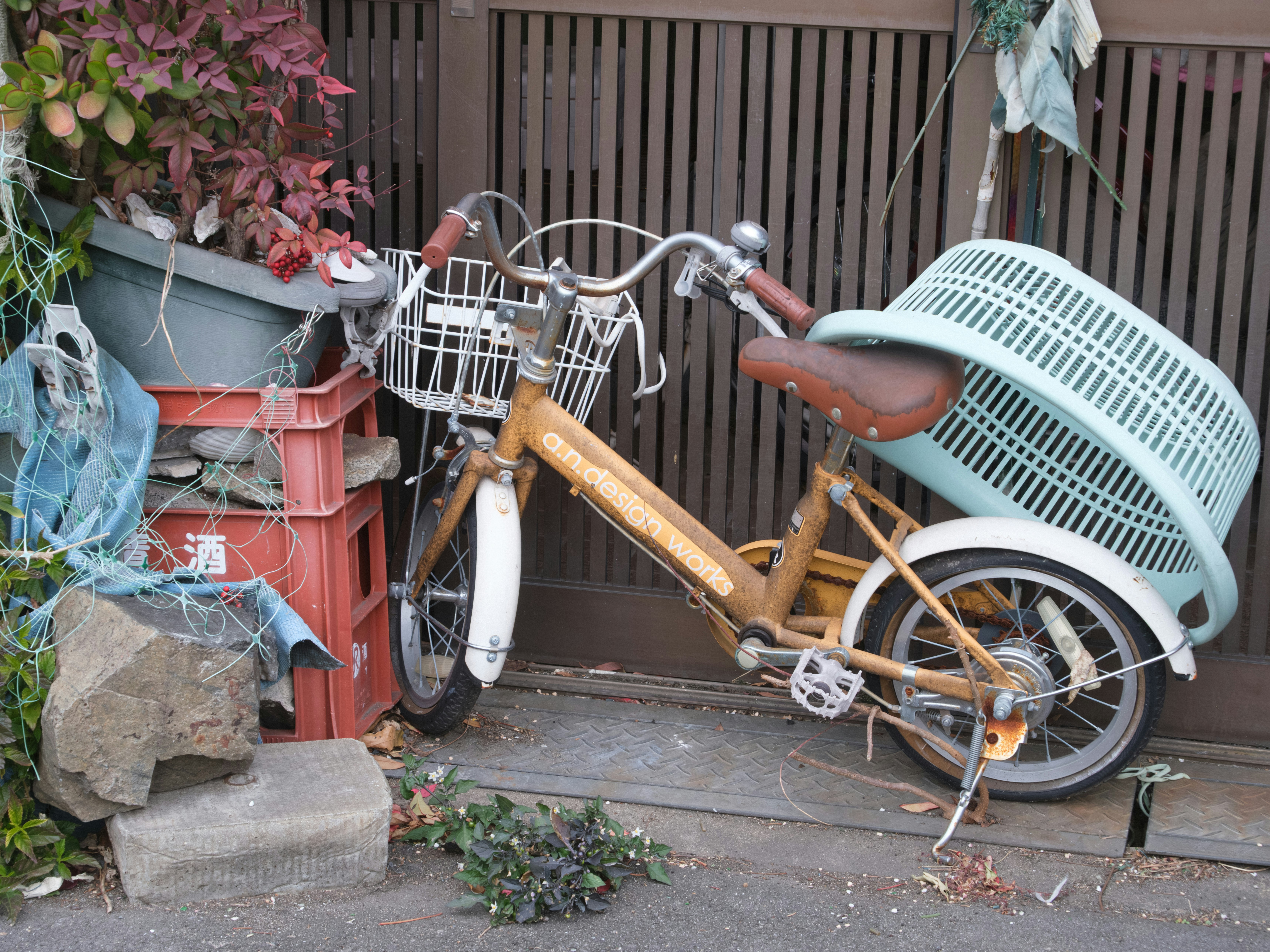 路地の壁際に並ぶ自転車と鉢植え