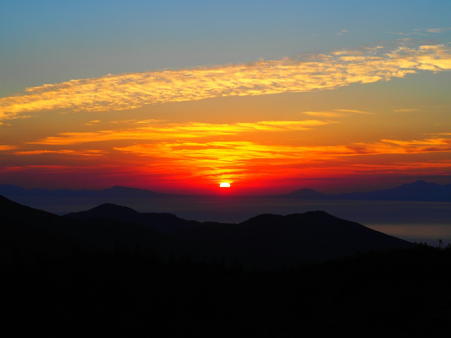 美麗的夕陽在山脈上空，色彩鮮豔