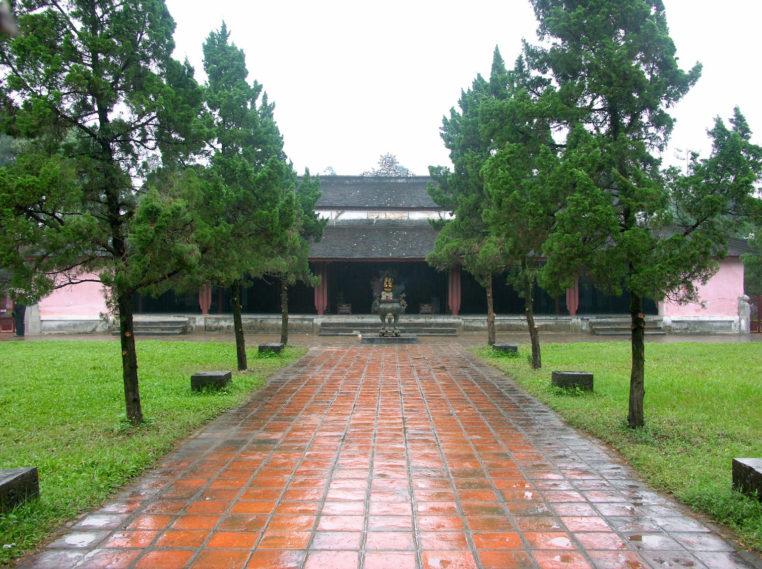 Pathway leading to a traditional building surrounded by trees