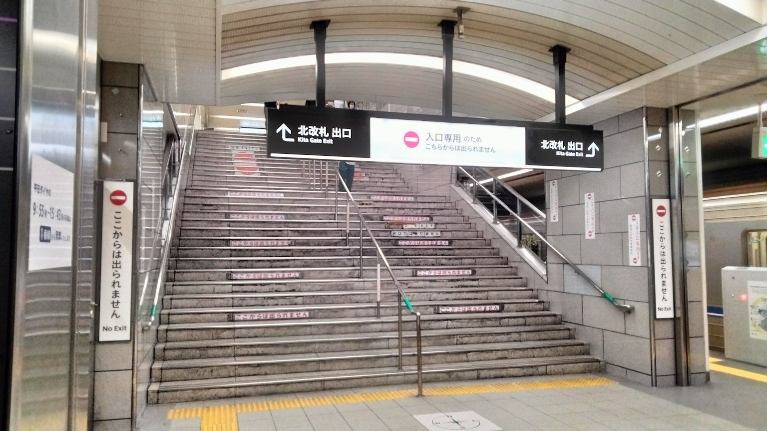 Entrata della scala della metropolitana con nome della stazione e segnaletica
