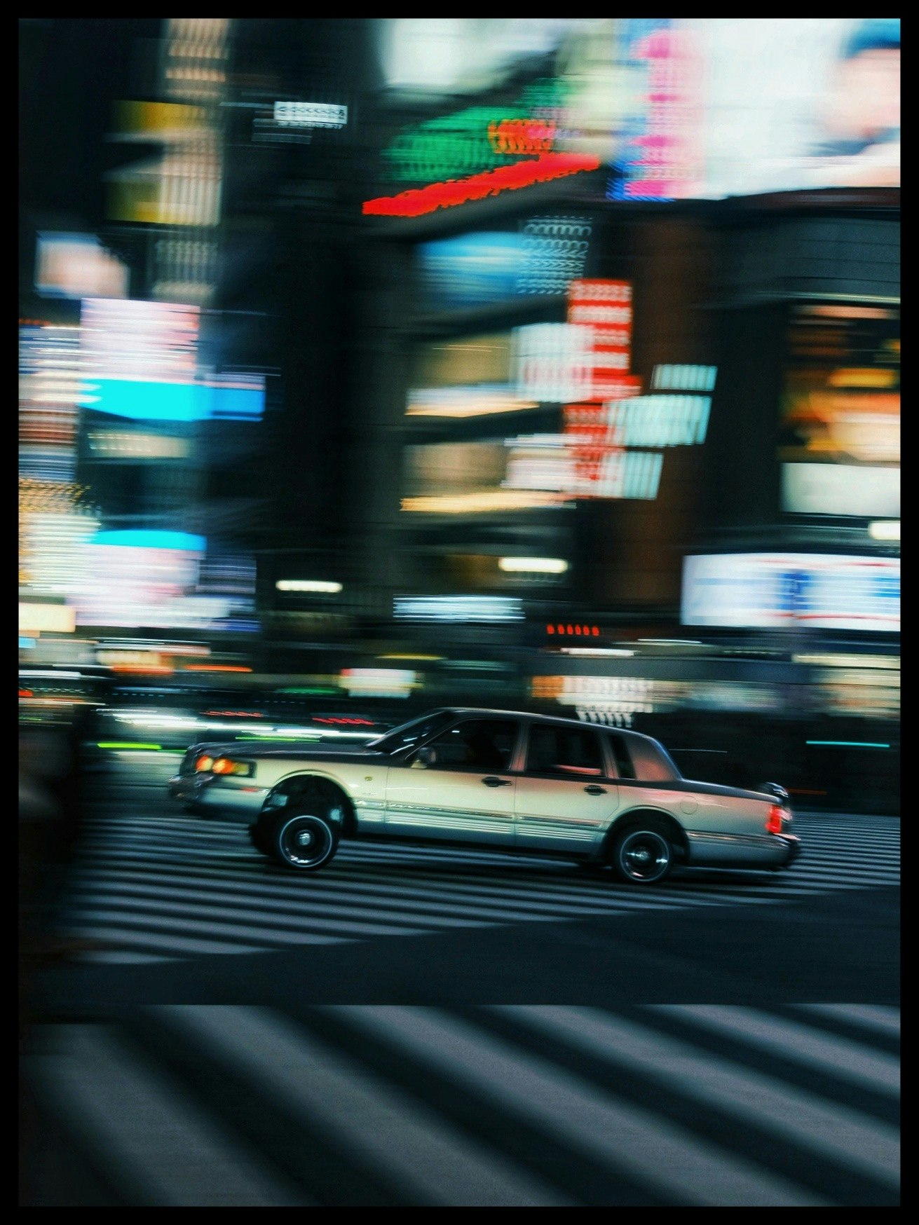 東京の繁華街で走るタクシーの動きのある写真
