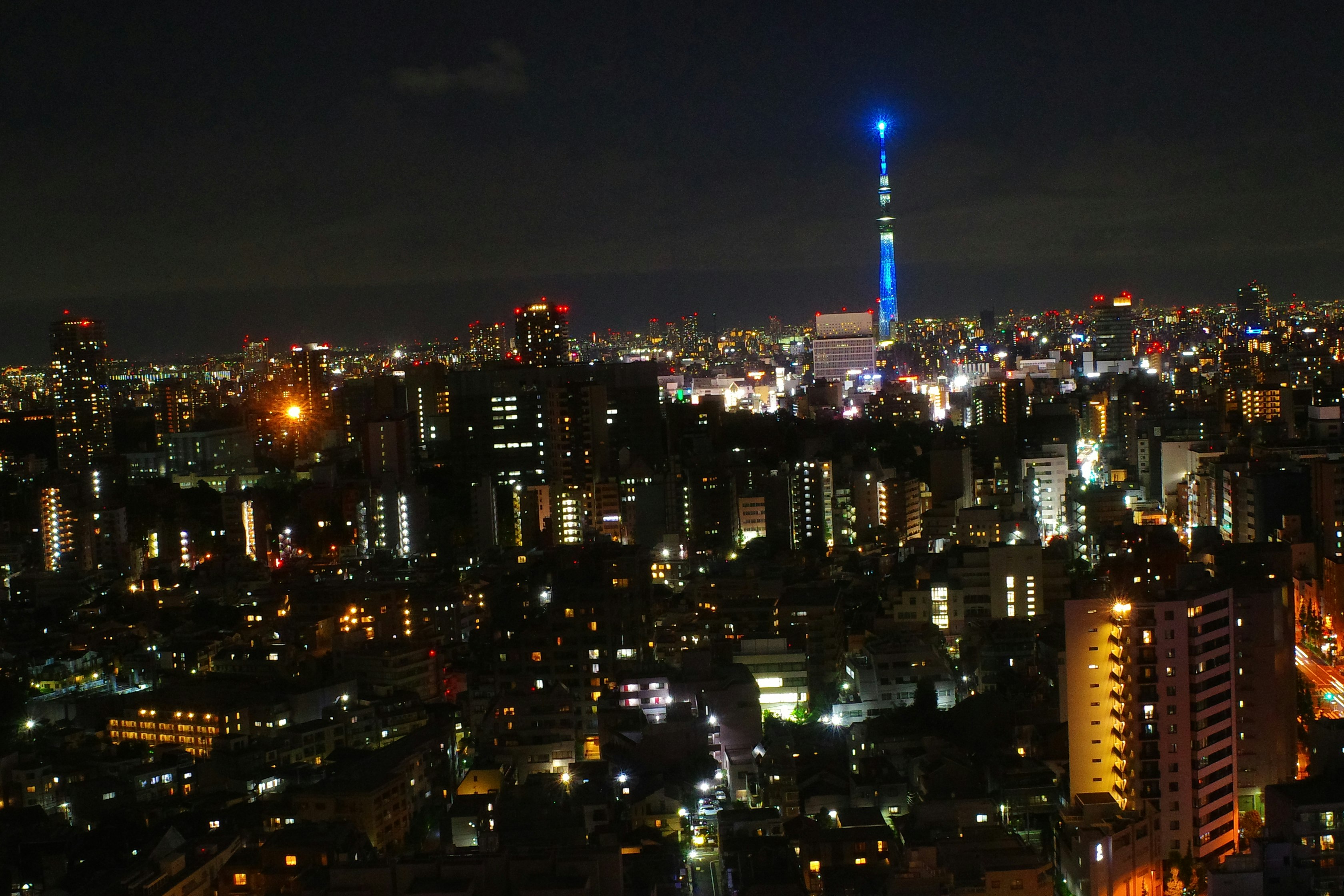 夜景の高層ビル群と青いタワーのある都市の街並み