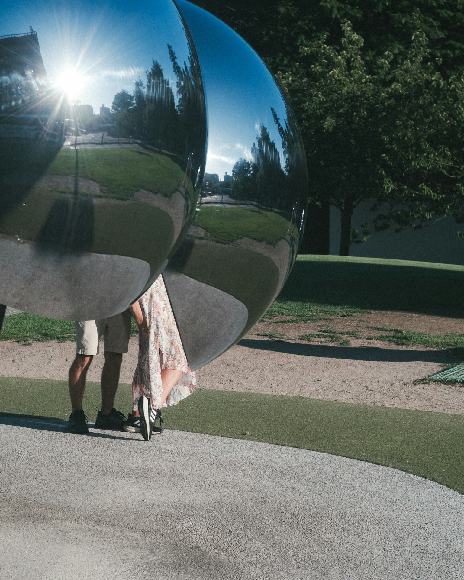 Große reflektierende Sphären in einem Park mit Menschen