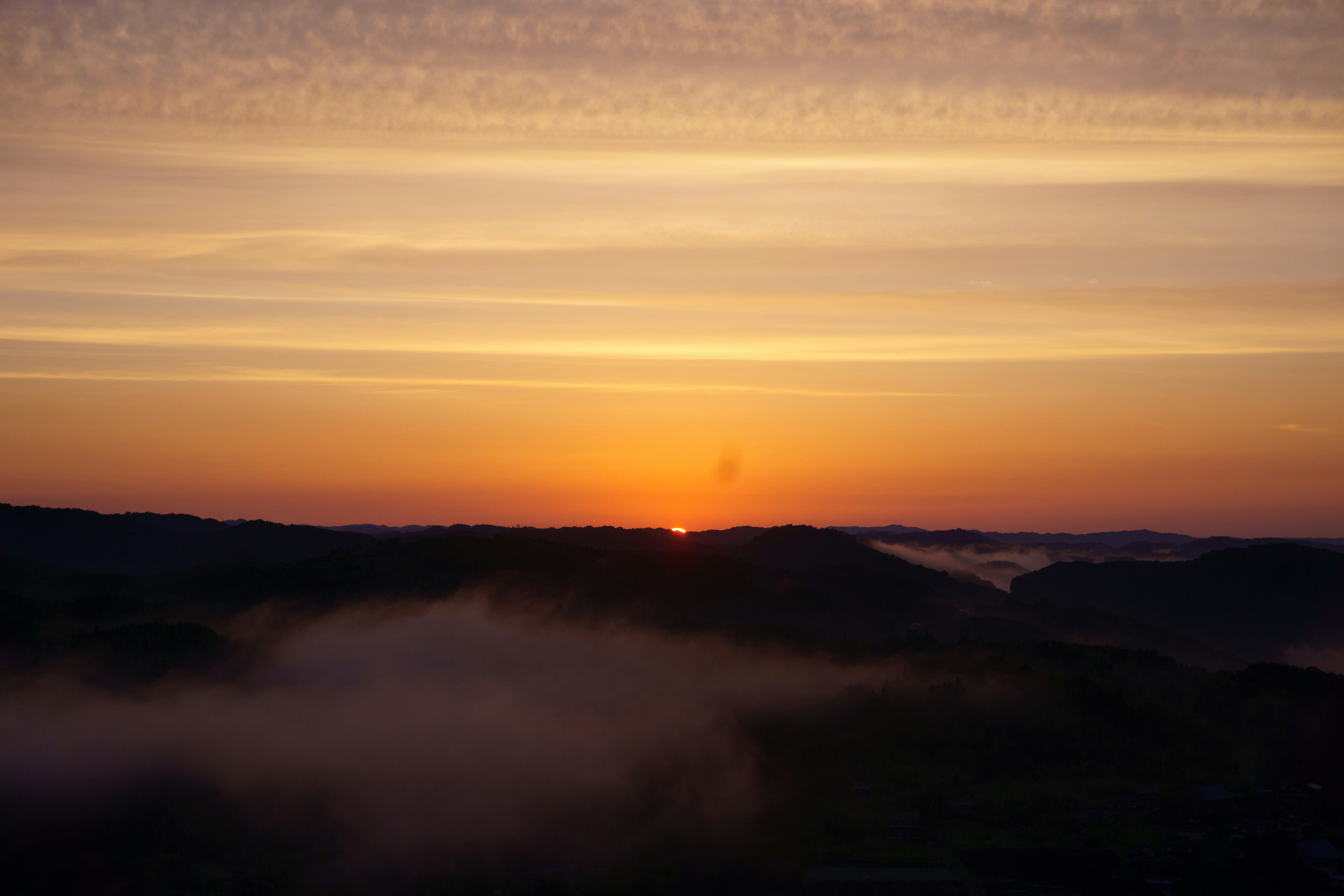 ciel de coucher de soleil au-dessus de crêtes de montagnes dans la brume