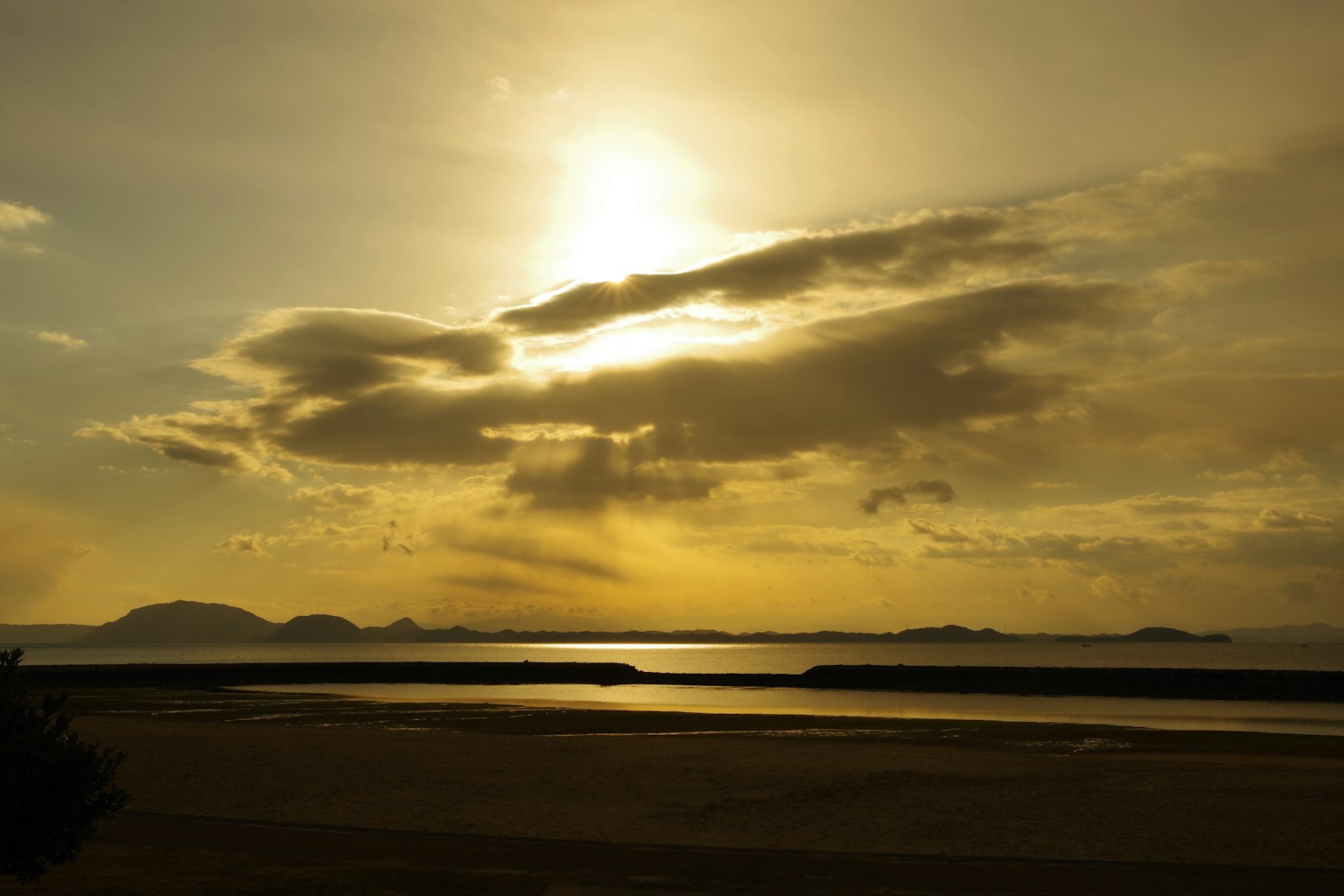 Tramonto che illumina il mare attraverso le nuvole