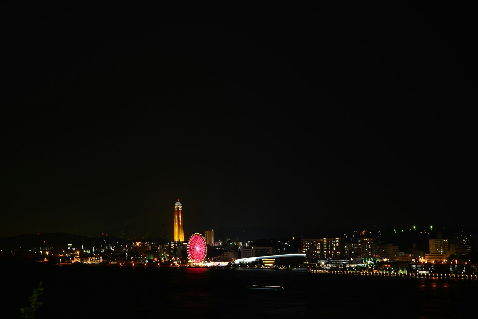 Vista nocturna de una ciudad portuaria con luces coloridas