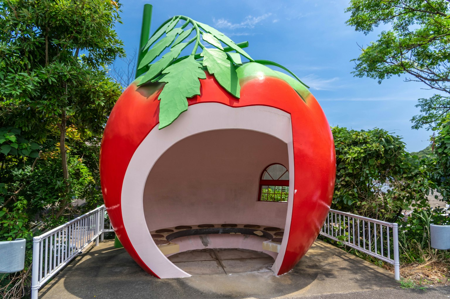 Red strawberry-shaped rest area featuring distinctive green leaves