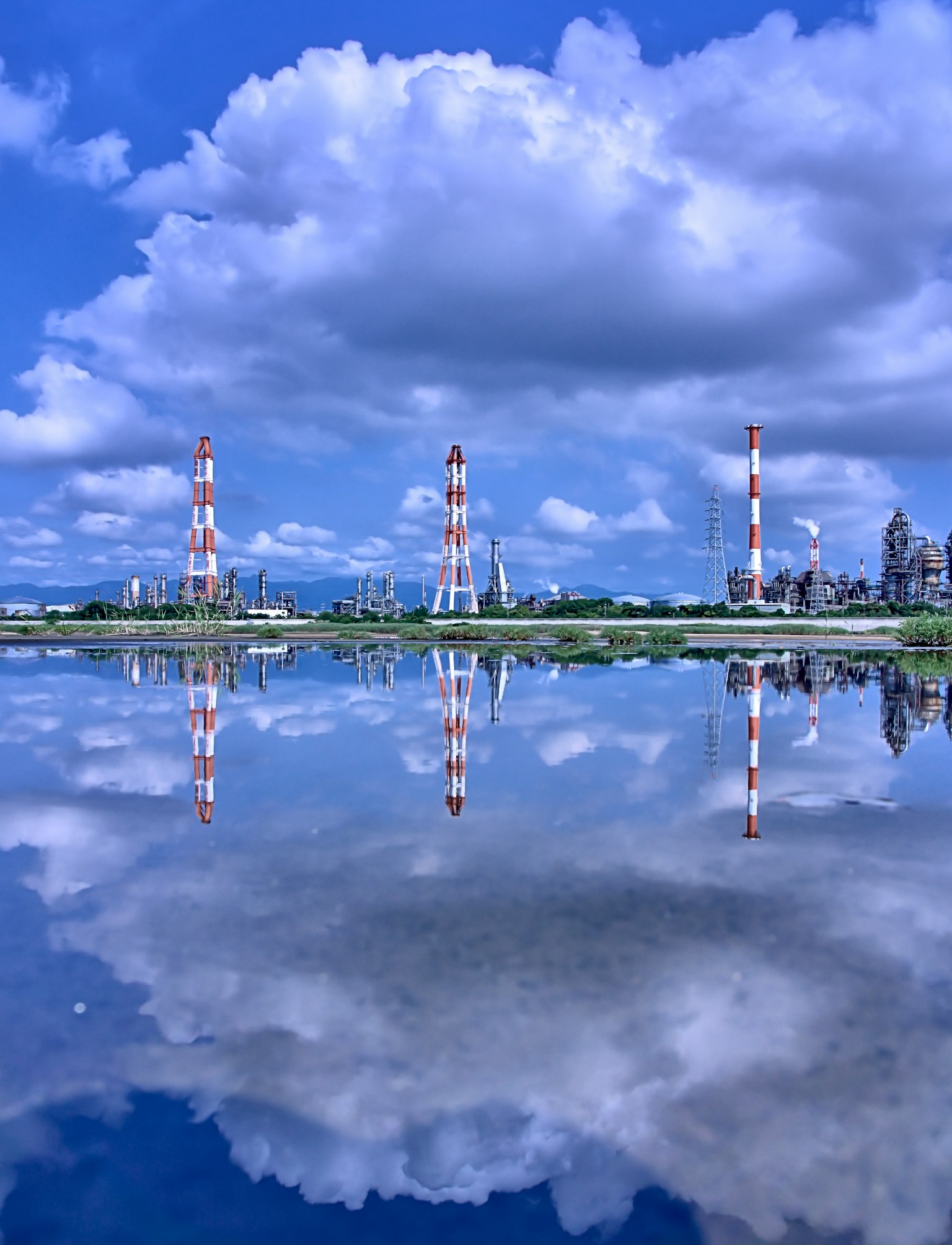 蓝天下水中反射的红白烟囱的风景