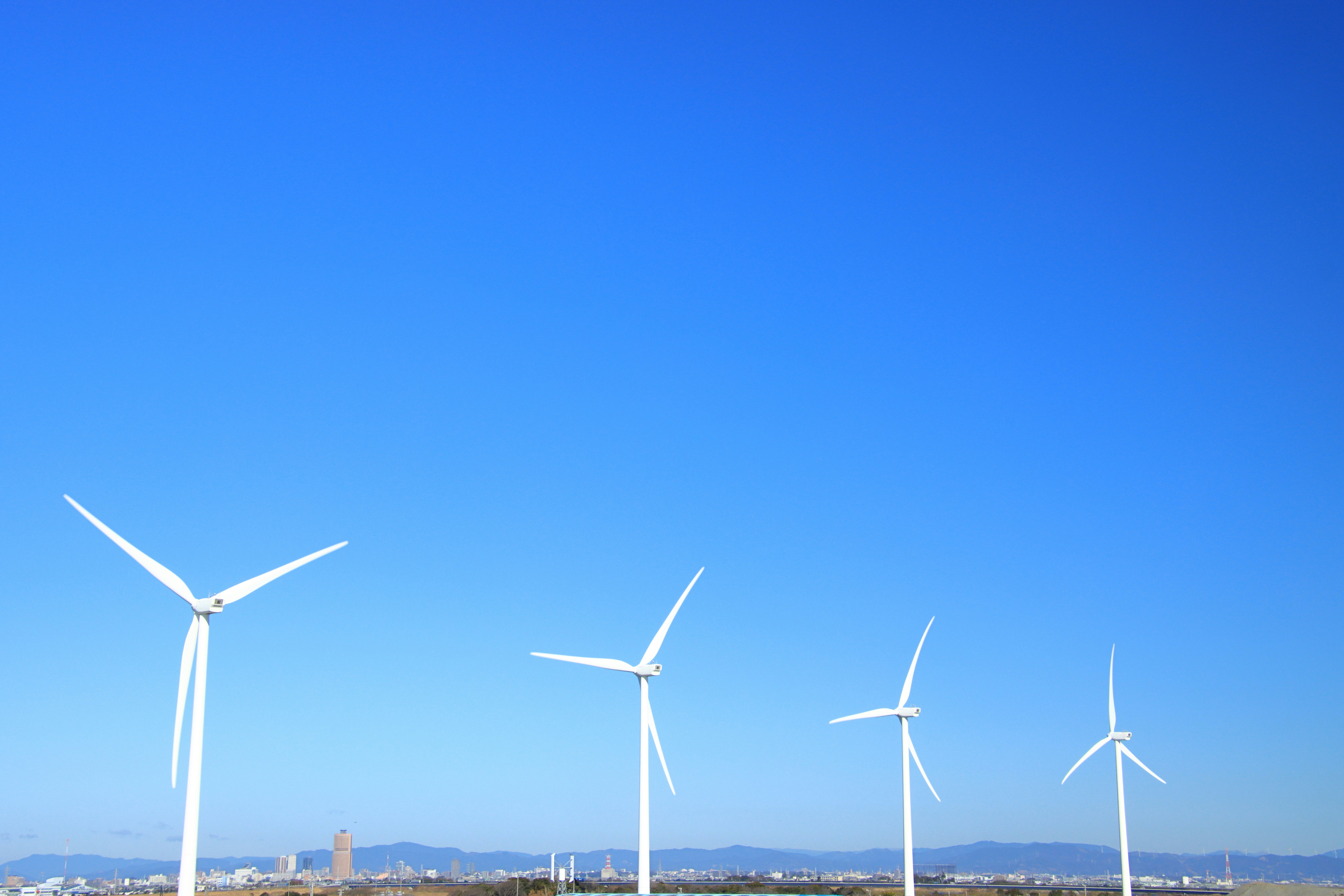 青空の下に並ぶ風力発電の風車