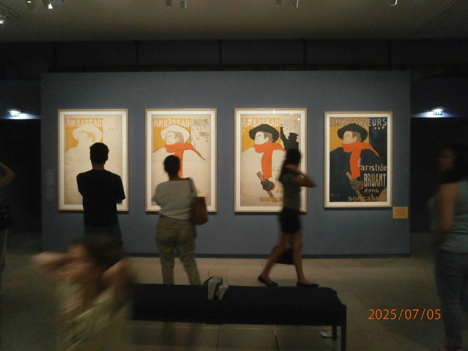 参观者在博物馆欣赏三件艺术作品