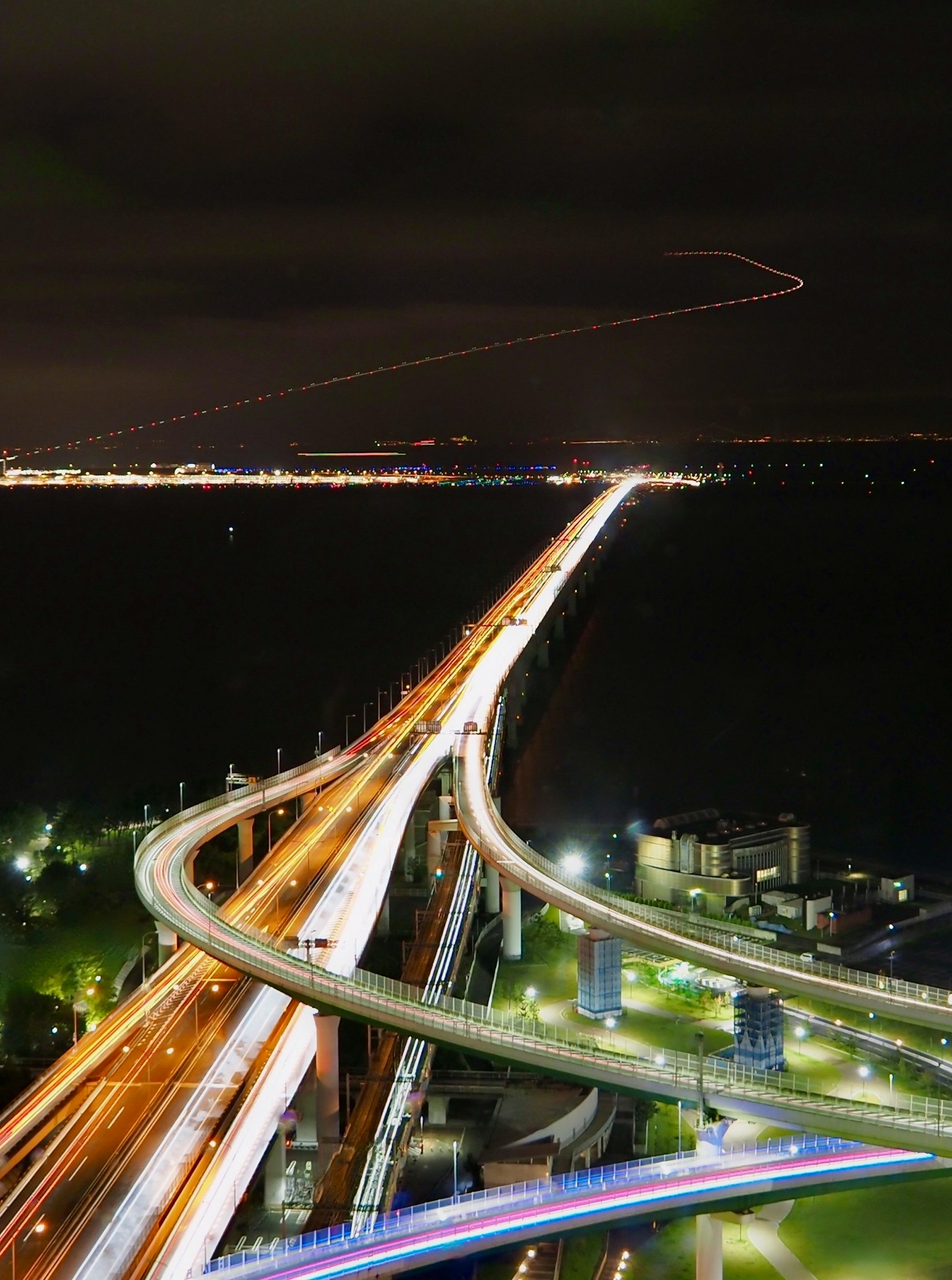 Vista nocturna de una carretera con luces de la ciudad y curvas
