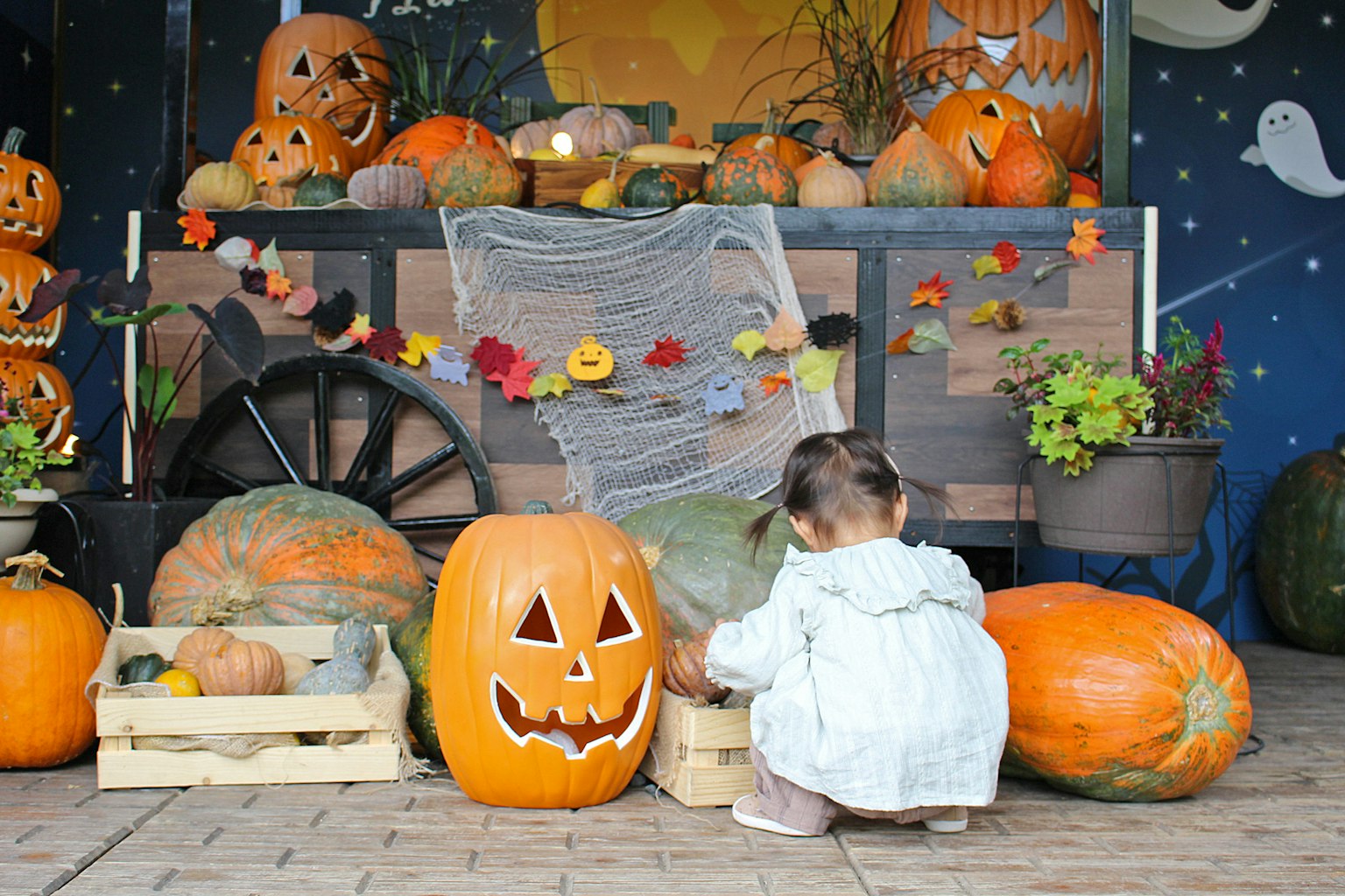 Un bambino che gioca davanti a una mostra di zucche di Halloween