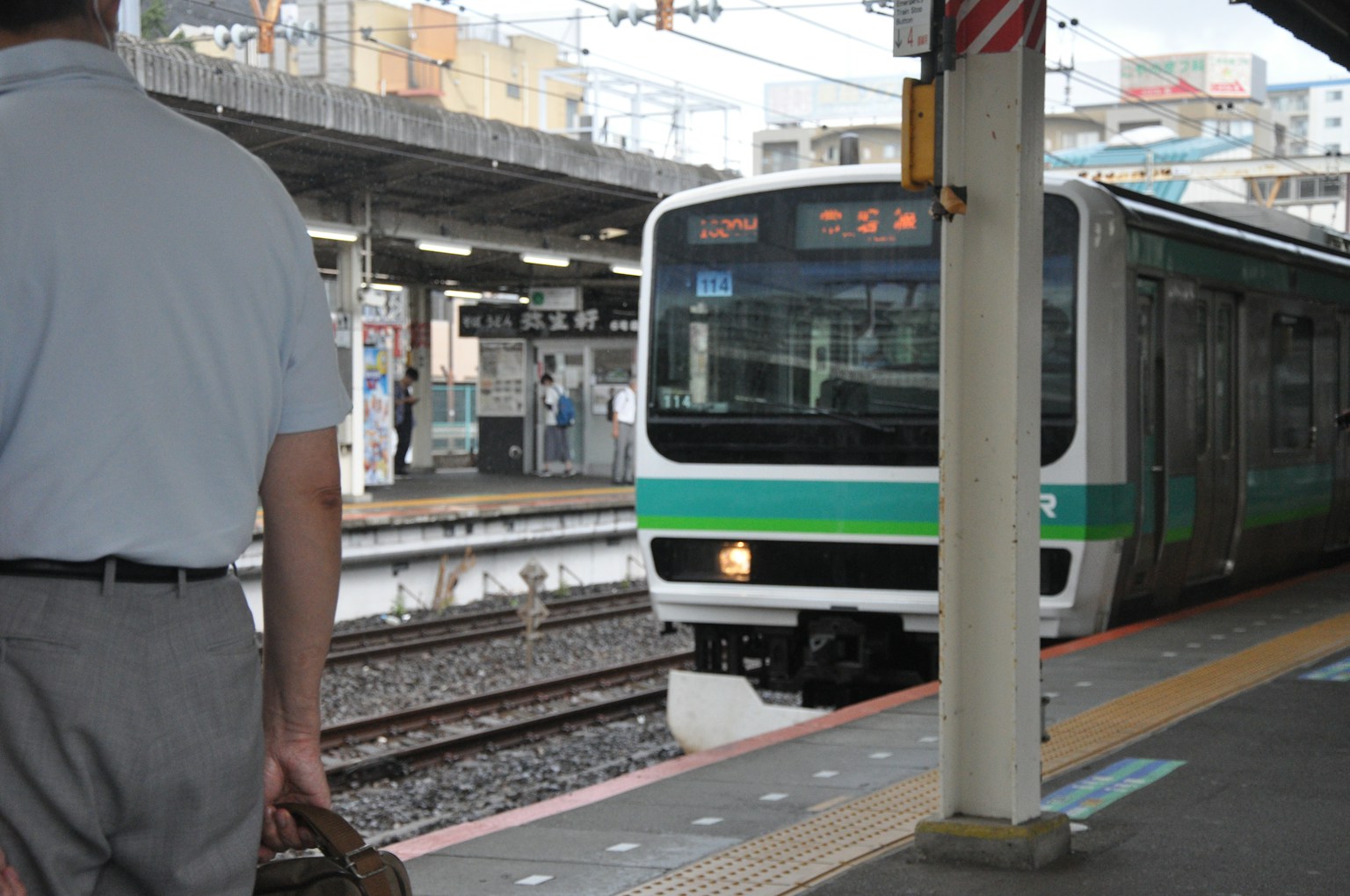 Seseorang menunggu di platform kereta dengan kereta yang datang