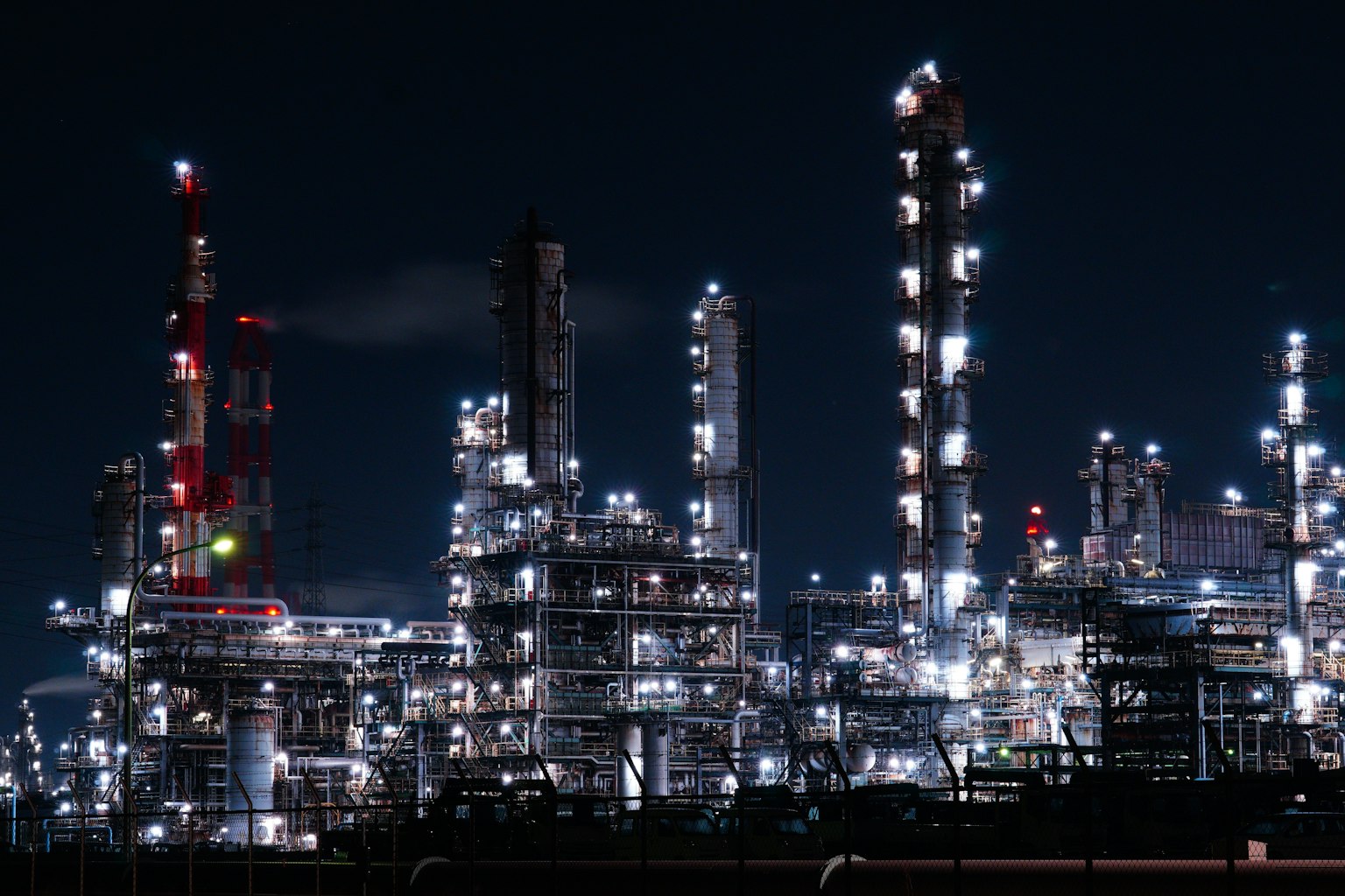 Paisaje brillante de una refinería de petróleo por la noche con estructuras iluminadas