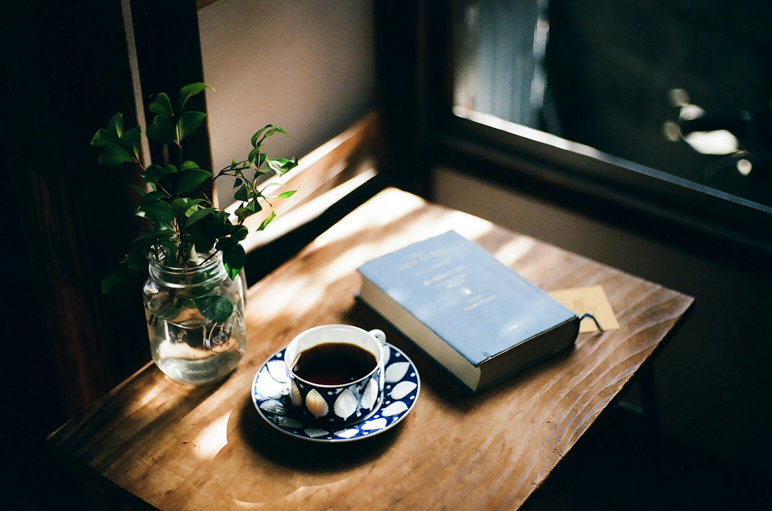 Una scena accogliente con una tazza di caffè e un libro su un tavolo di legno