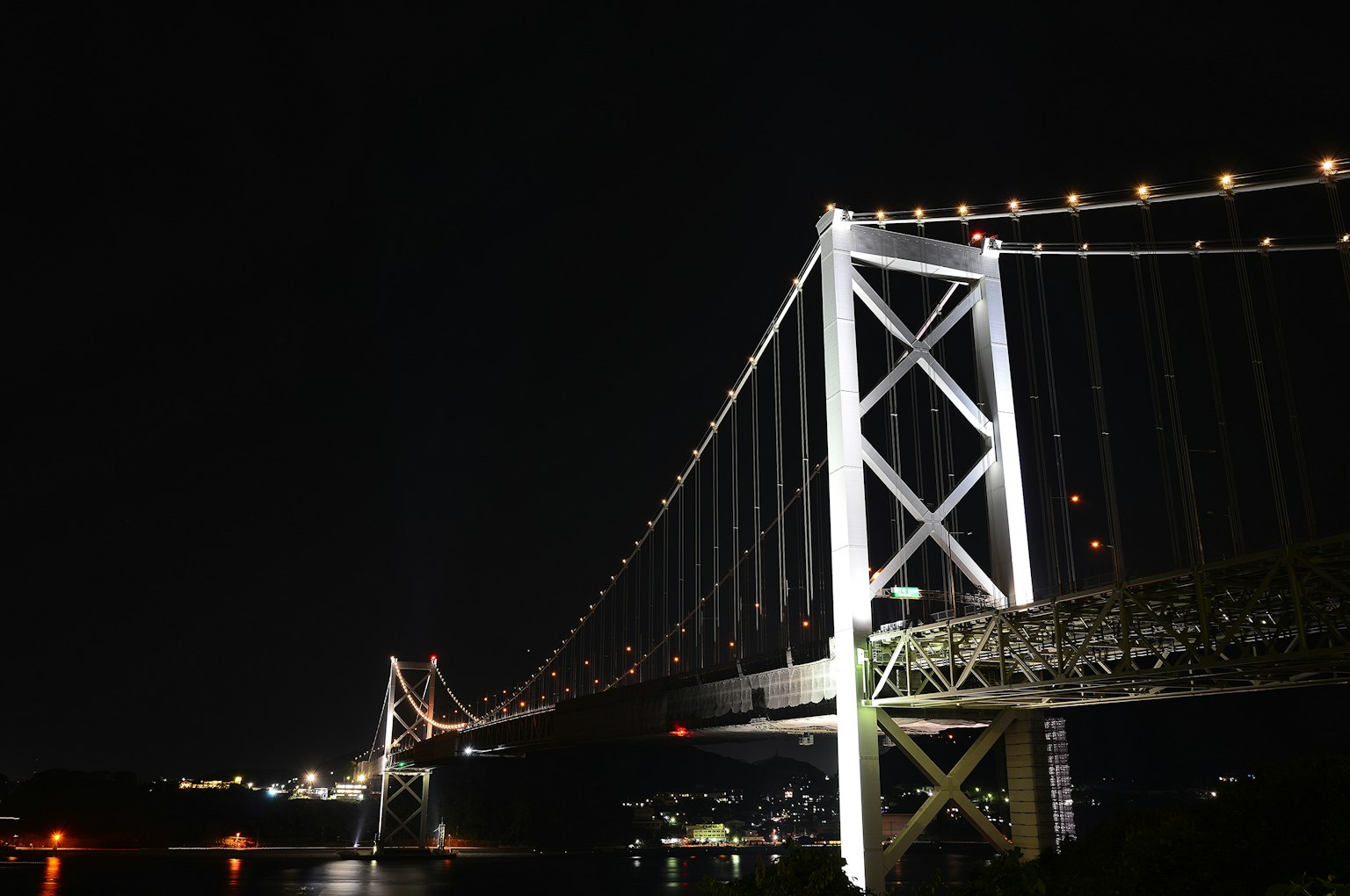 Puente iluminado de noche con luces de la ciudad