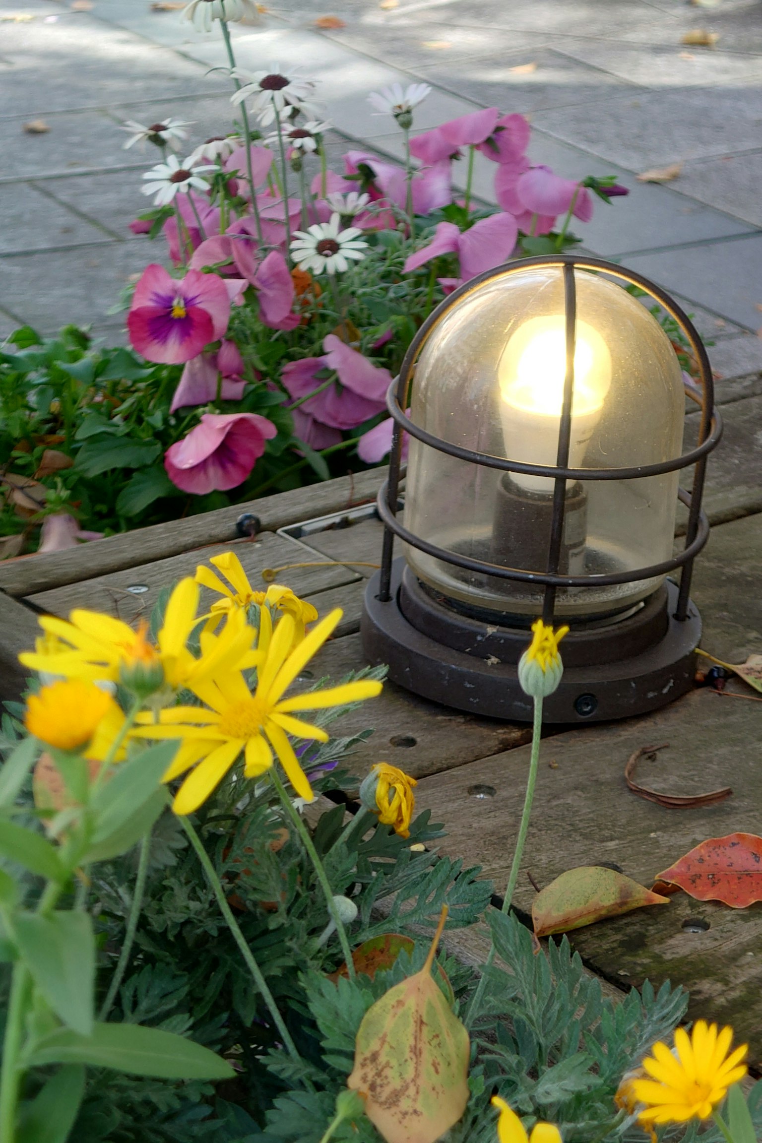 Gartenszene mit bunten Blumen und einer dekorativen Lampe