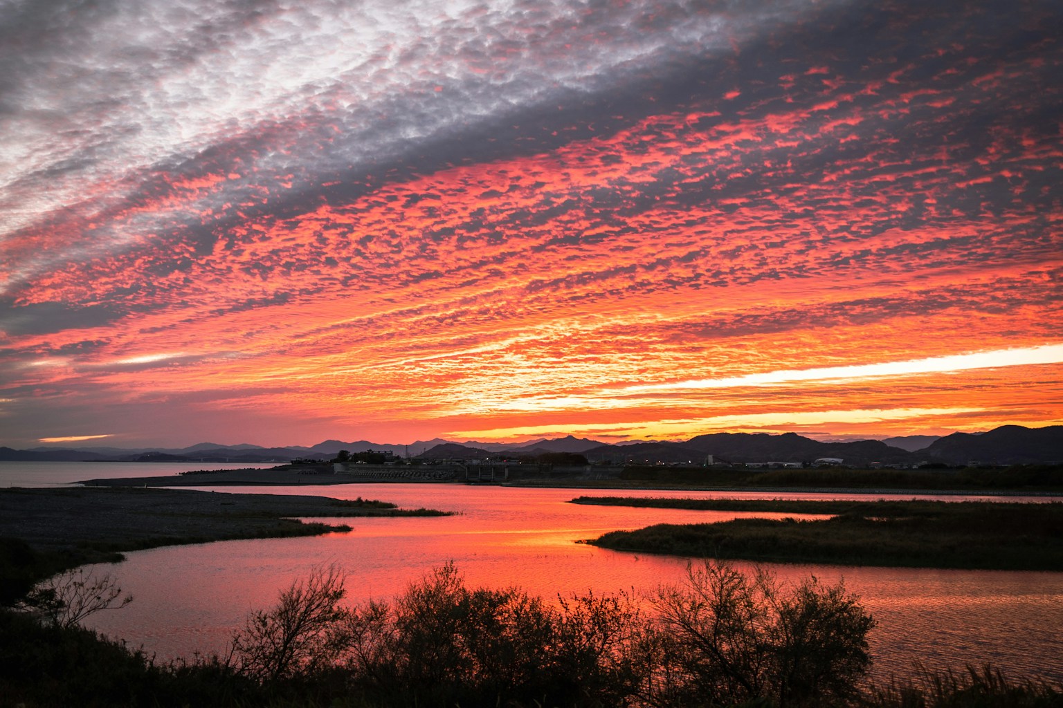 Atemberaubender Sonnenuntergang über einem ruhigen Fluss mit lebhaften Farben